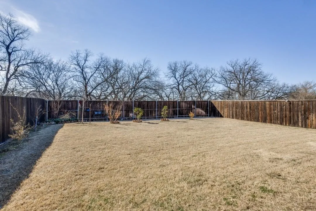 Expansive backyard featuring a fenced perimeter and mature trees