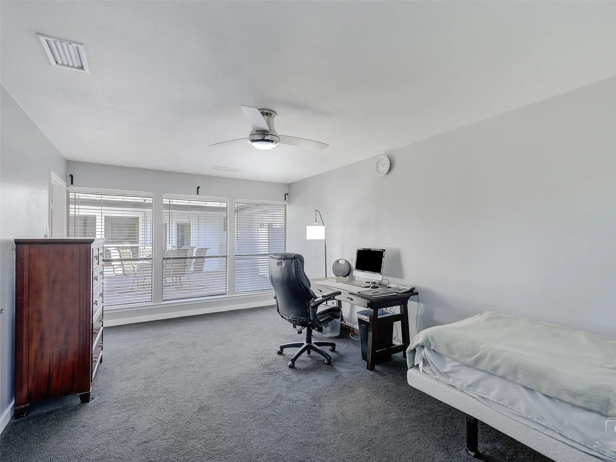 Carpeted office space with ceiling fan