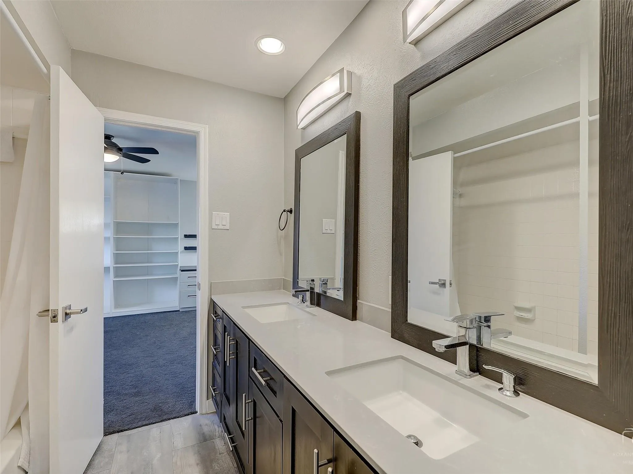 Bathroom with double vanity, tile floors, and ceiling fan