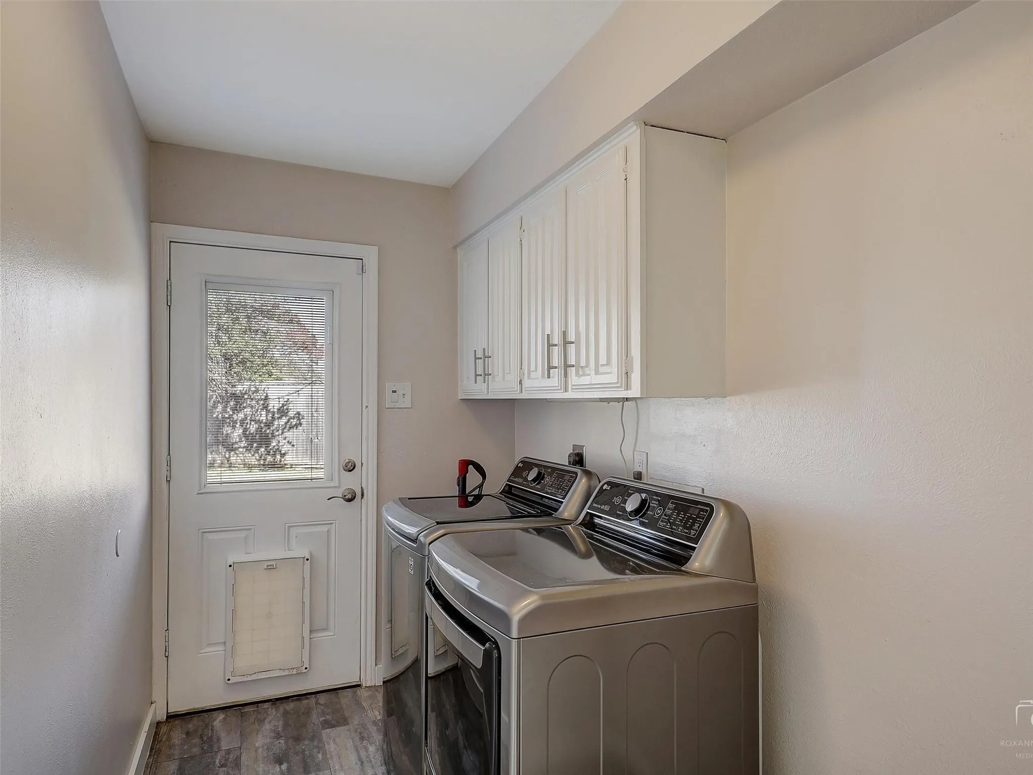 Laundry room featuring electric dryer hookup, independent washer and dryer, cabinets, and dark wood-type flooring