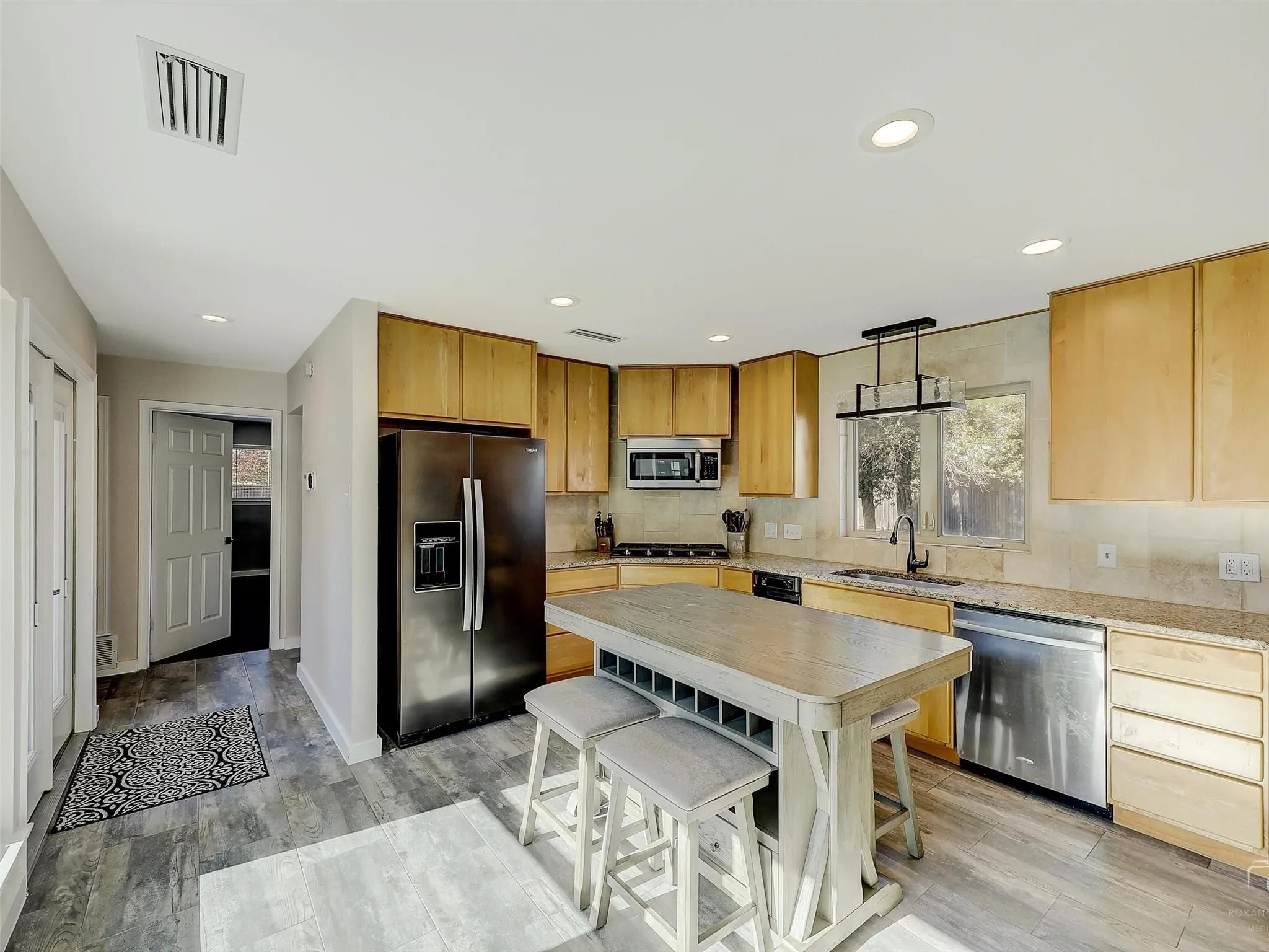 Kitchen featuring light stone counters, tasteful backsplash, sink, and stainless steel appliances