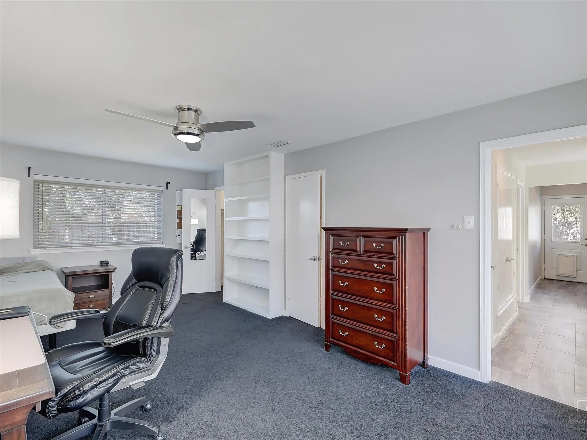 Carpeted home office with ceiling fan