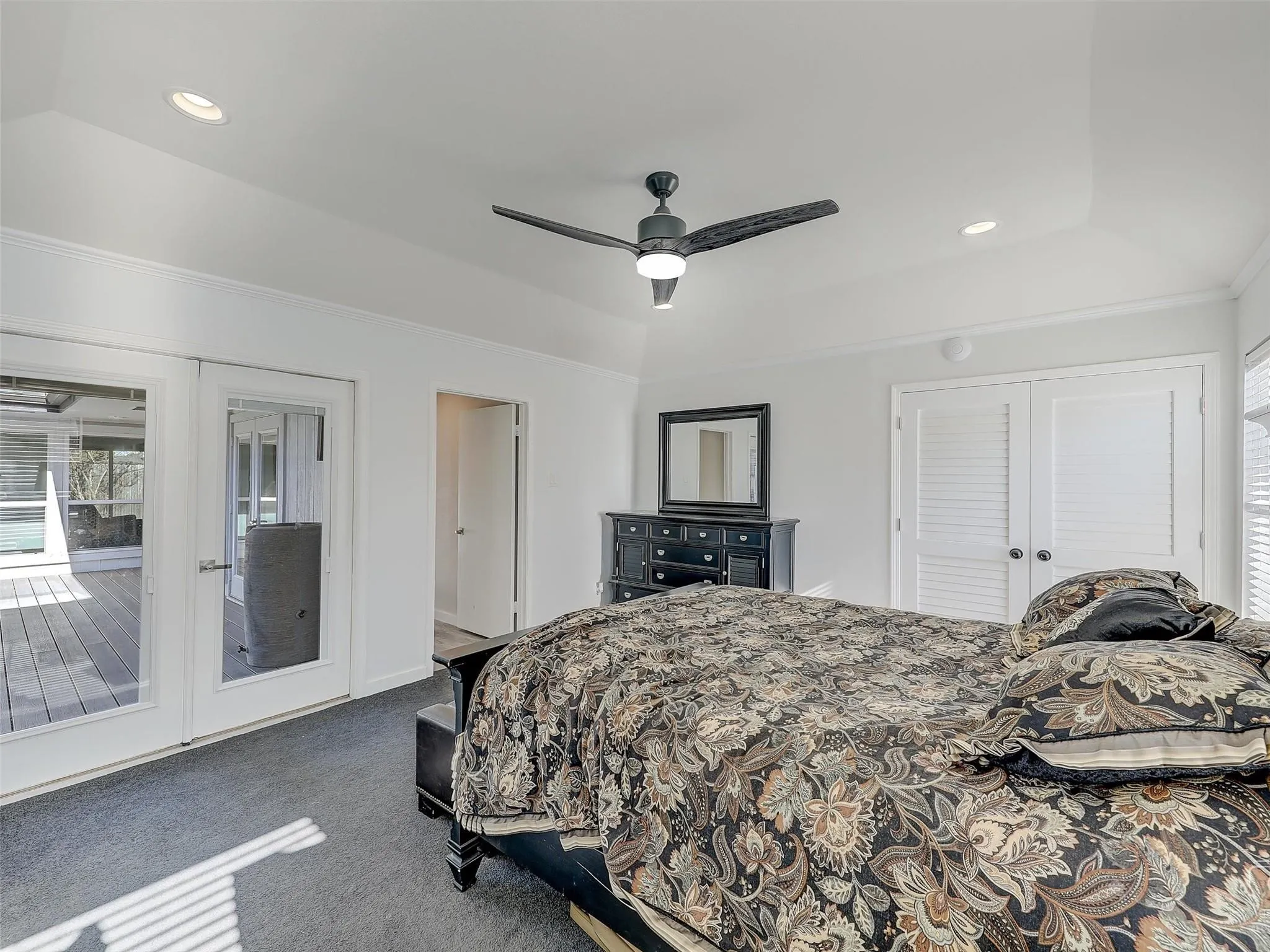 Carpeted bedroom featuring french doors, ceiling fan, access to exterior, a closet, and a raised​​‌​​​​‌​​‌‌​‌‌​​​‌‌​‌​‌​‌​​​‌​​ ceiling