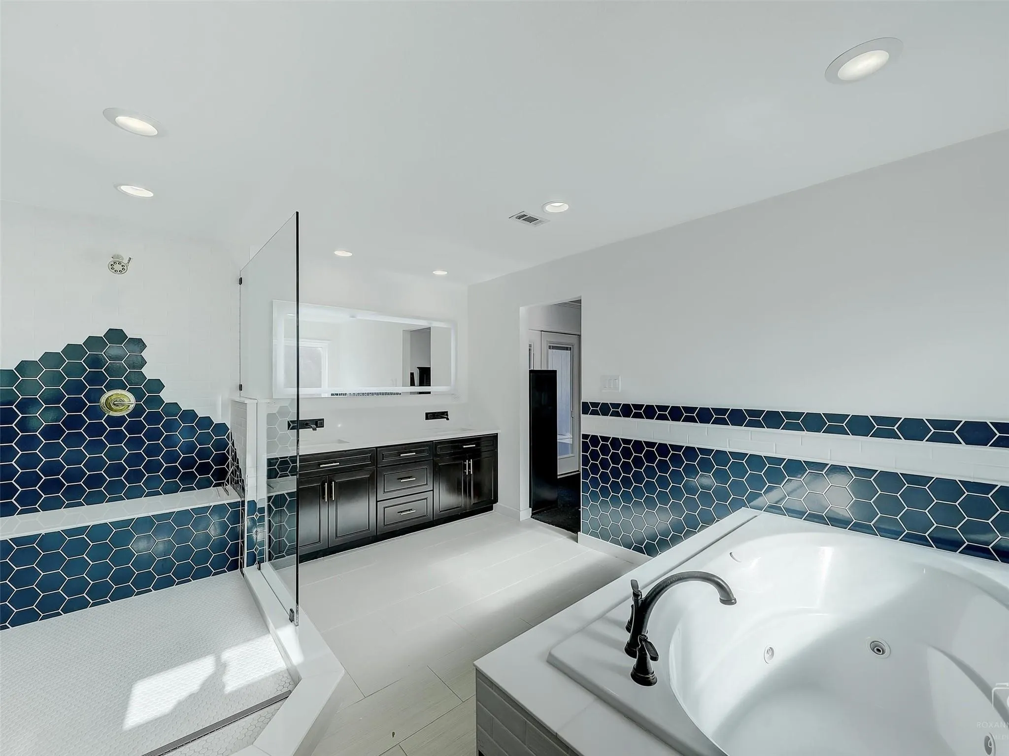 Bathroom featuring tile flooring, vanity, and plus walk in shower