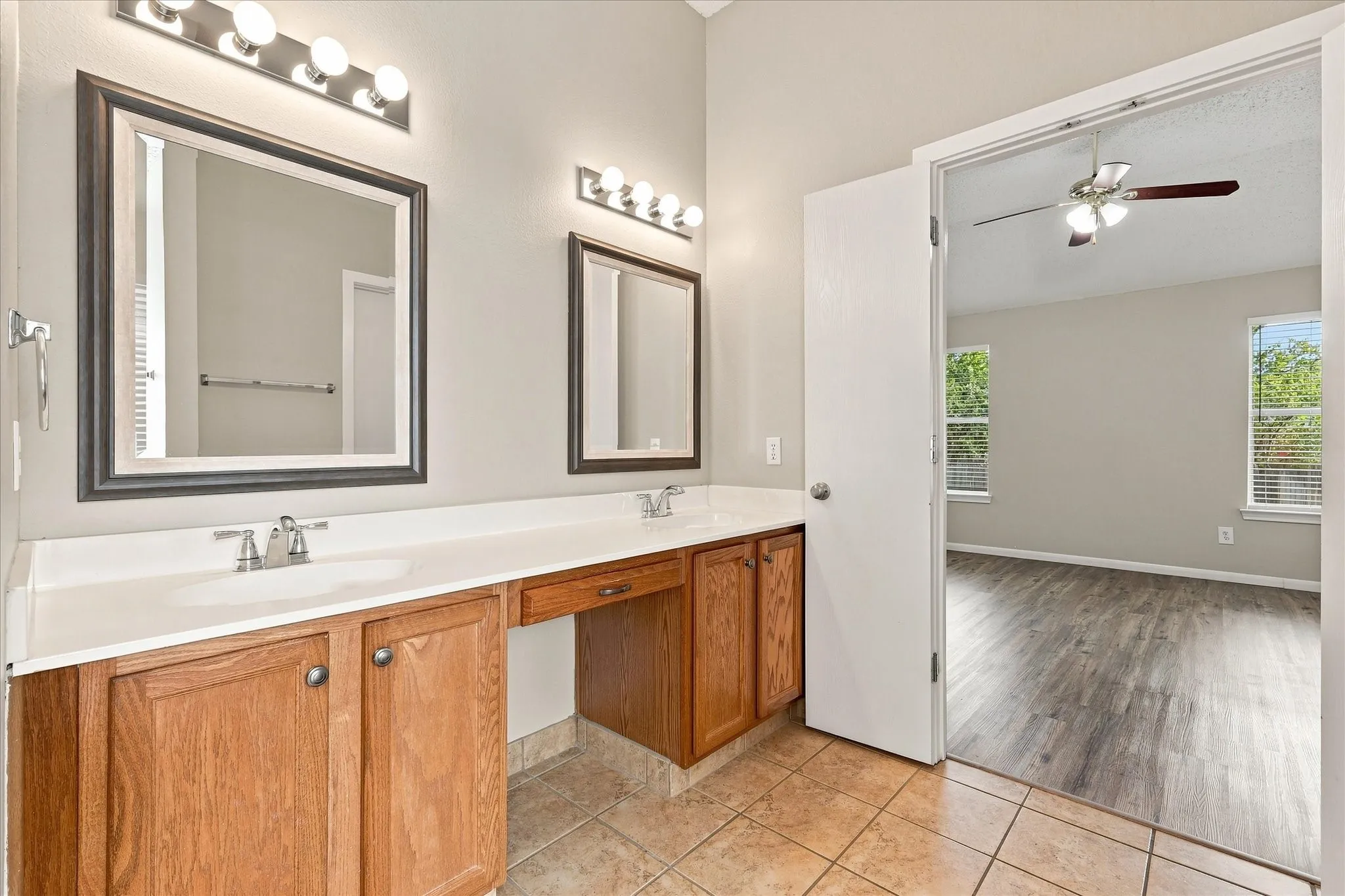 Dual vanity with integrated sinks, wood cabinetry, and a dedicated vanity area