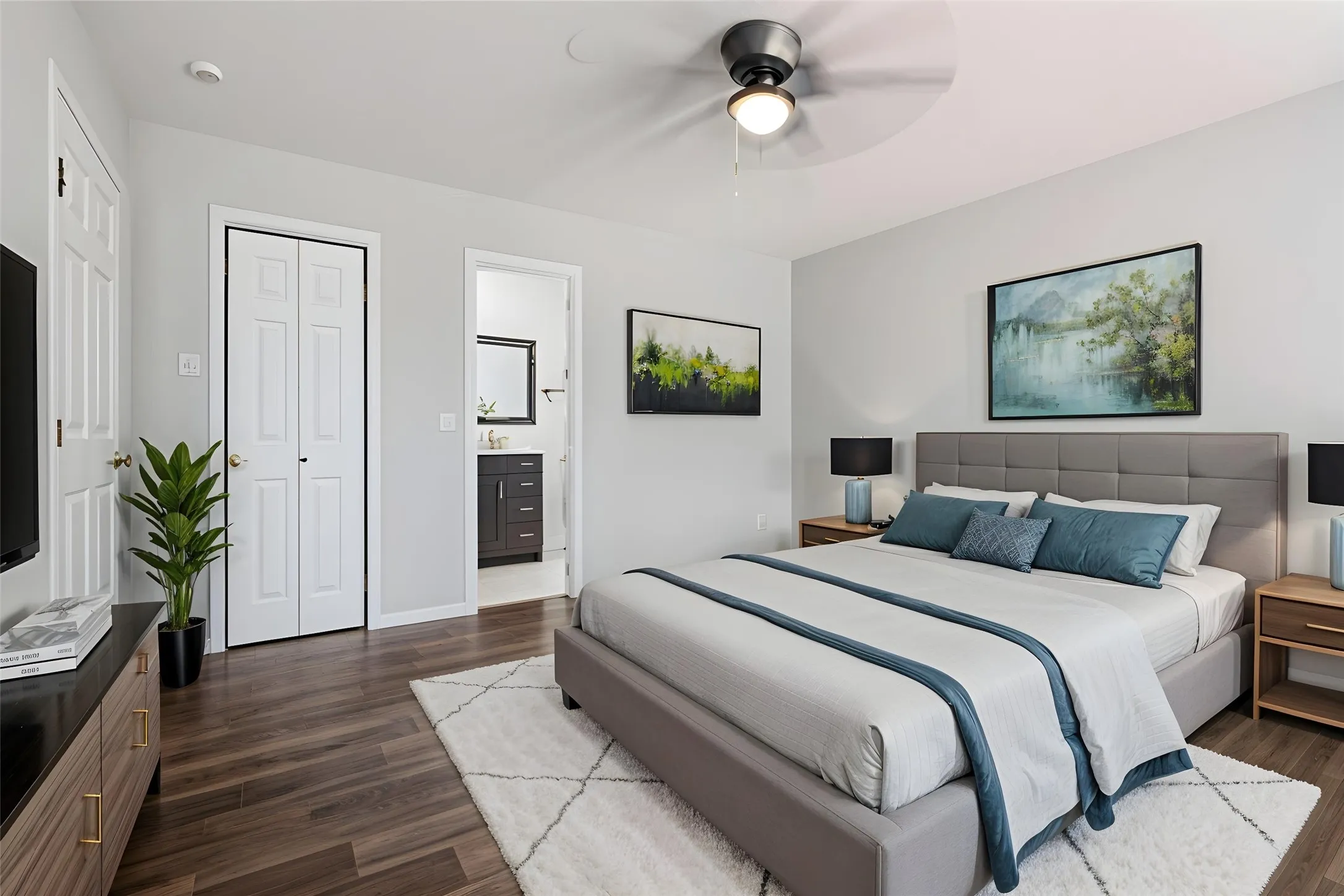Wood-finish flooring throughout, light gray walls, ceiling fan with integrated lighting, and a bi-fold closet door