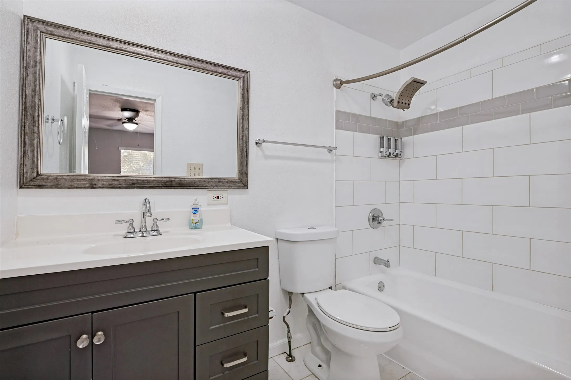 White subway tile shower surround with a gray accent band