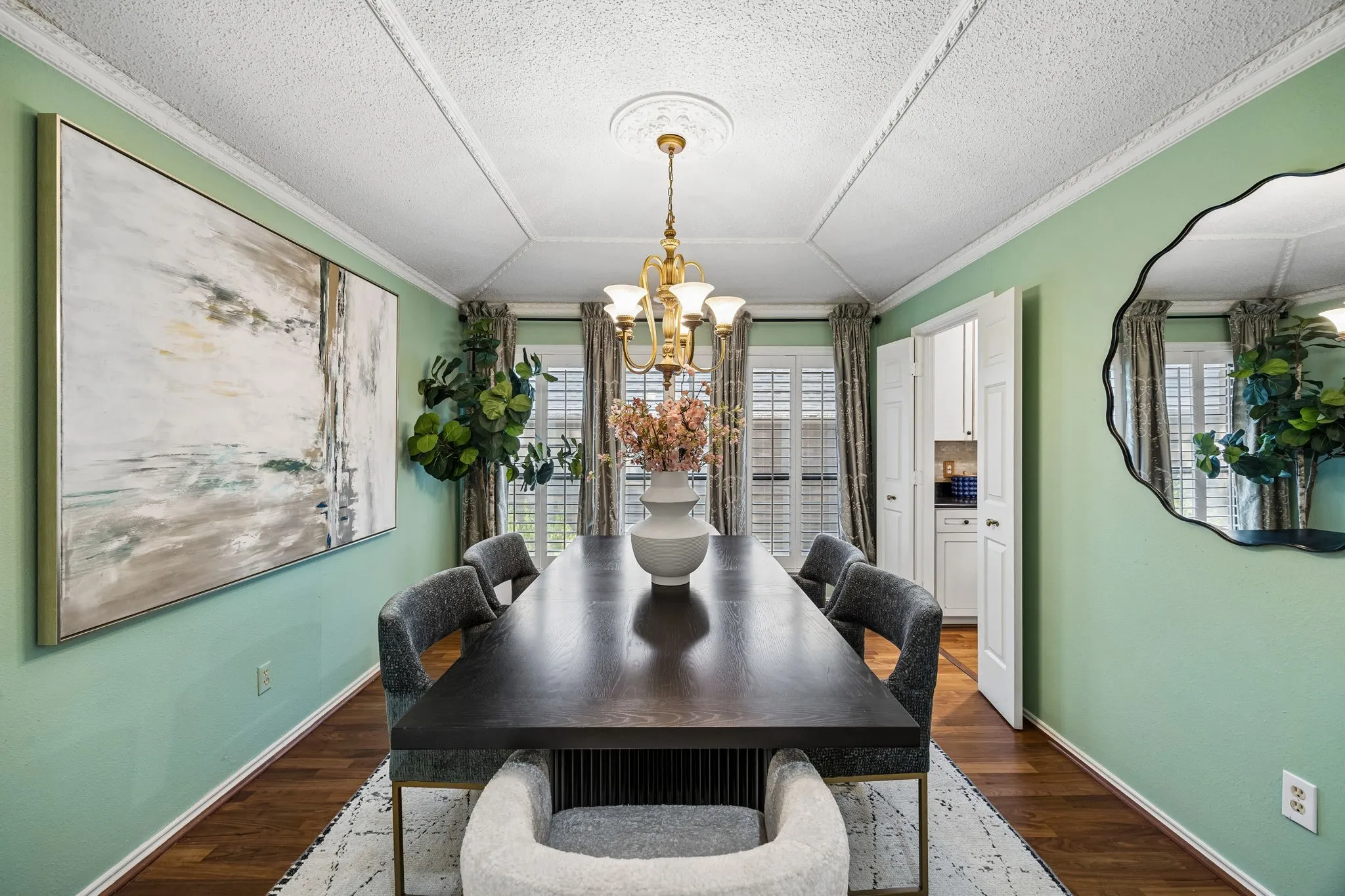 The dining room features plantation shutters, wood floors and original trim details.