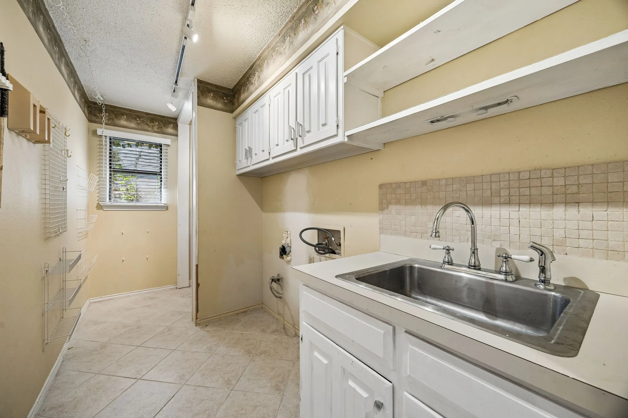 The laundry room features lots of storage and a sink.