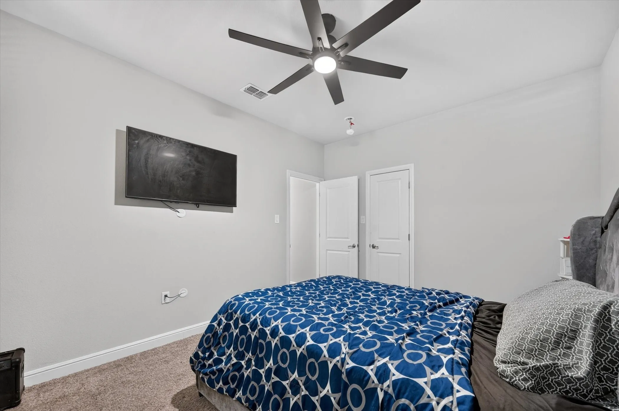 Carpet flooring, ceiling fan with integrated lighting, and white paneled doors