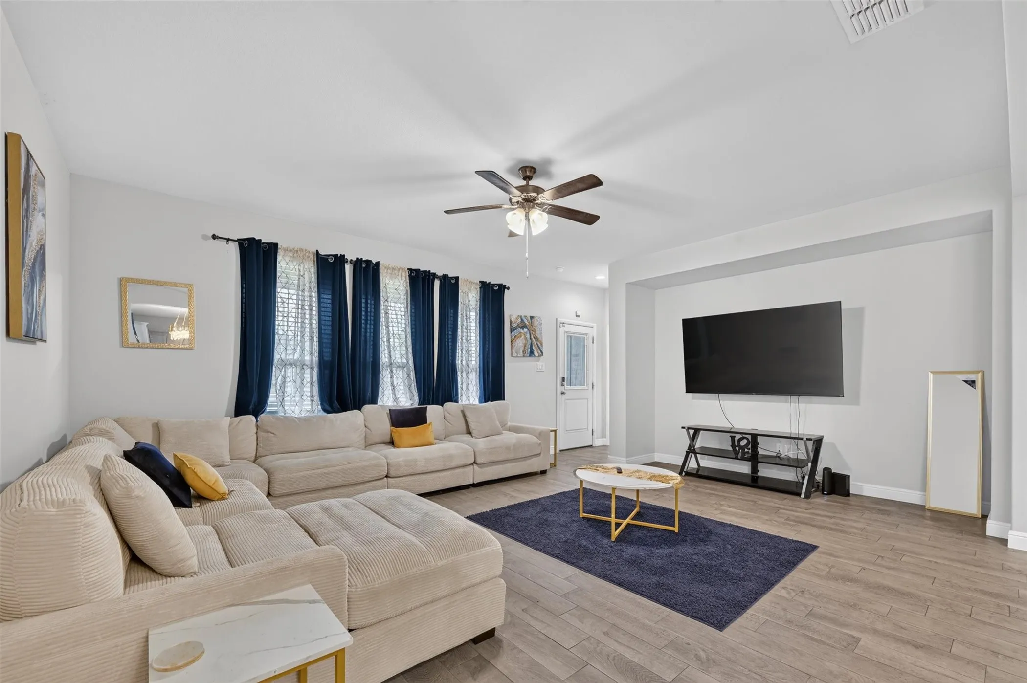 Spacious living area featuring wood-finish flooring, recessed lighting, and a ceiling fan