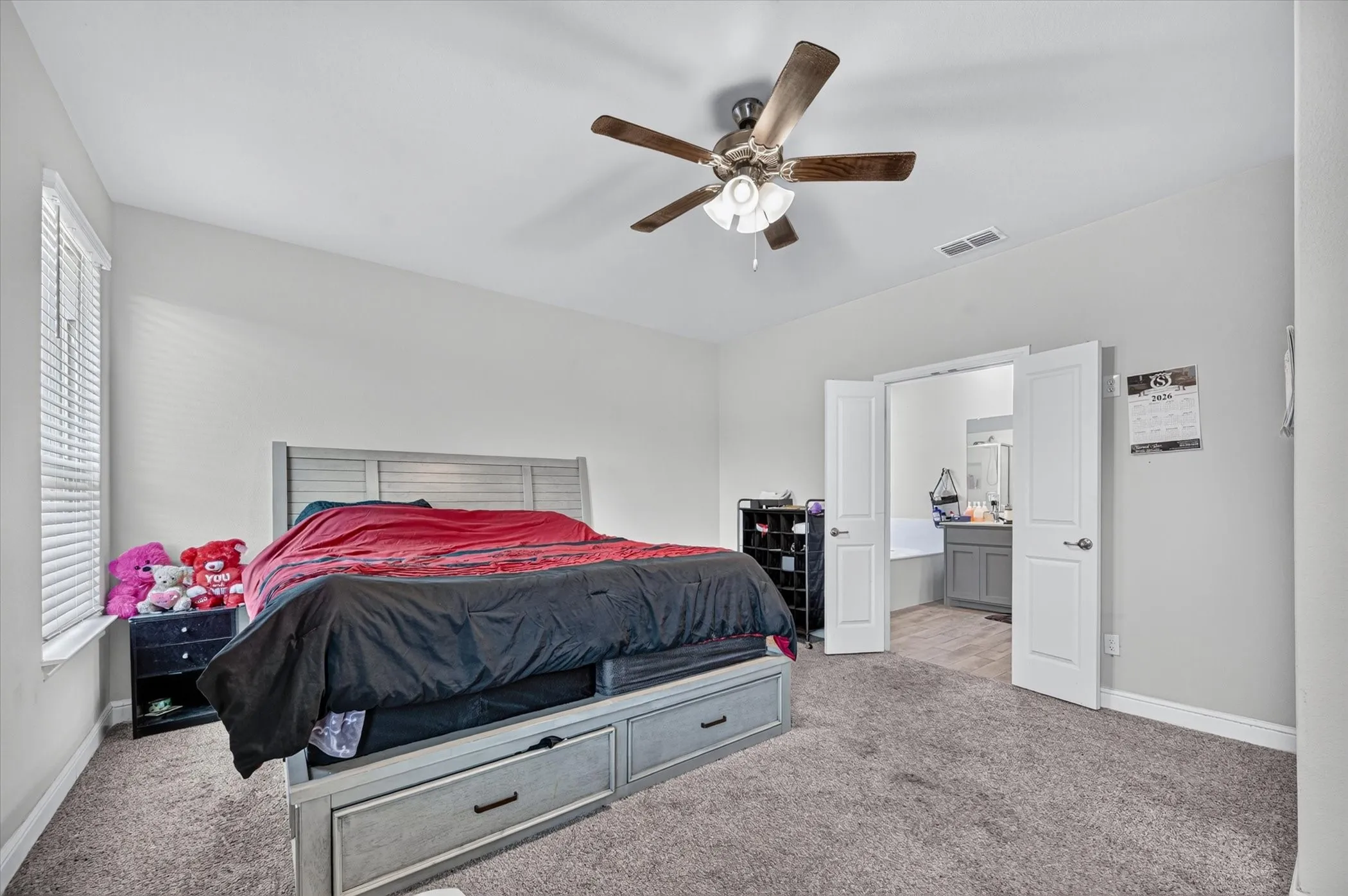 Neutral wall color, ceiling fan with integrated lighting, window with blinds, and white double doors