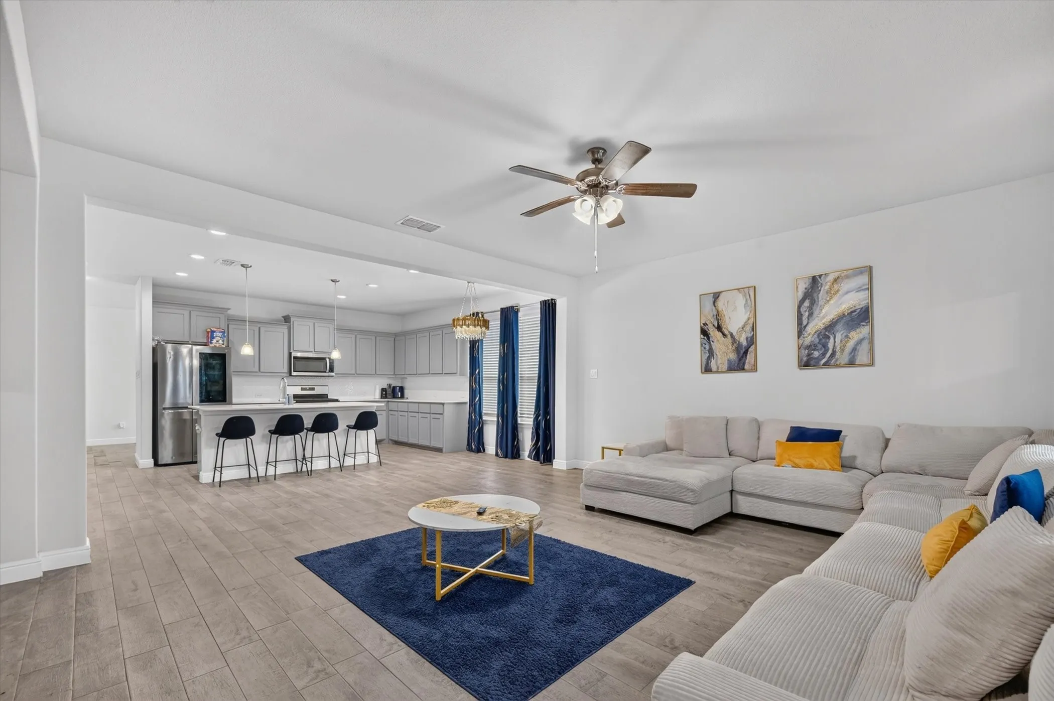Open-concept living area featuring wood-finish flooring, a ceiling fan, and recessed lighting