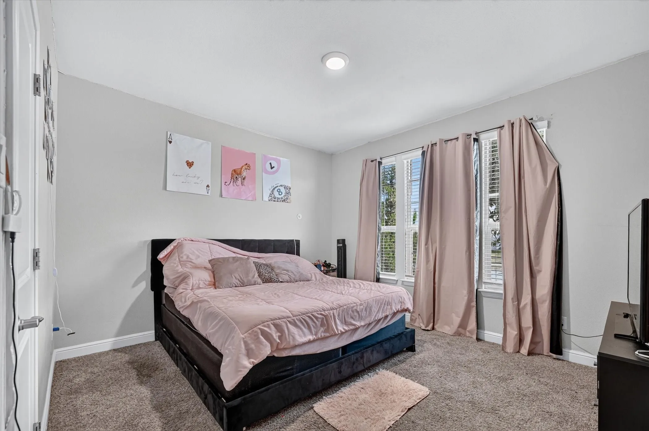 Recessed lighting illuminates this room featuring wall-to-wall carpeting and multiple windows