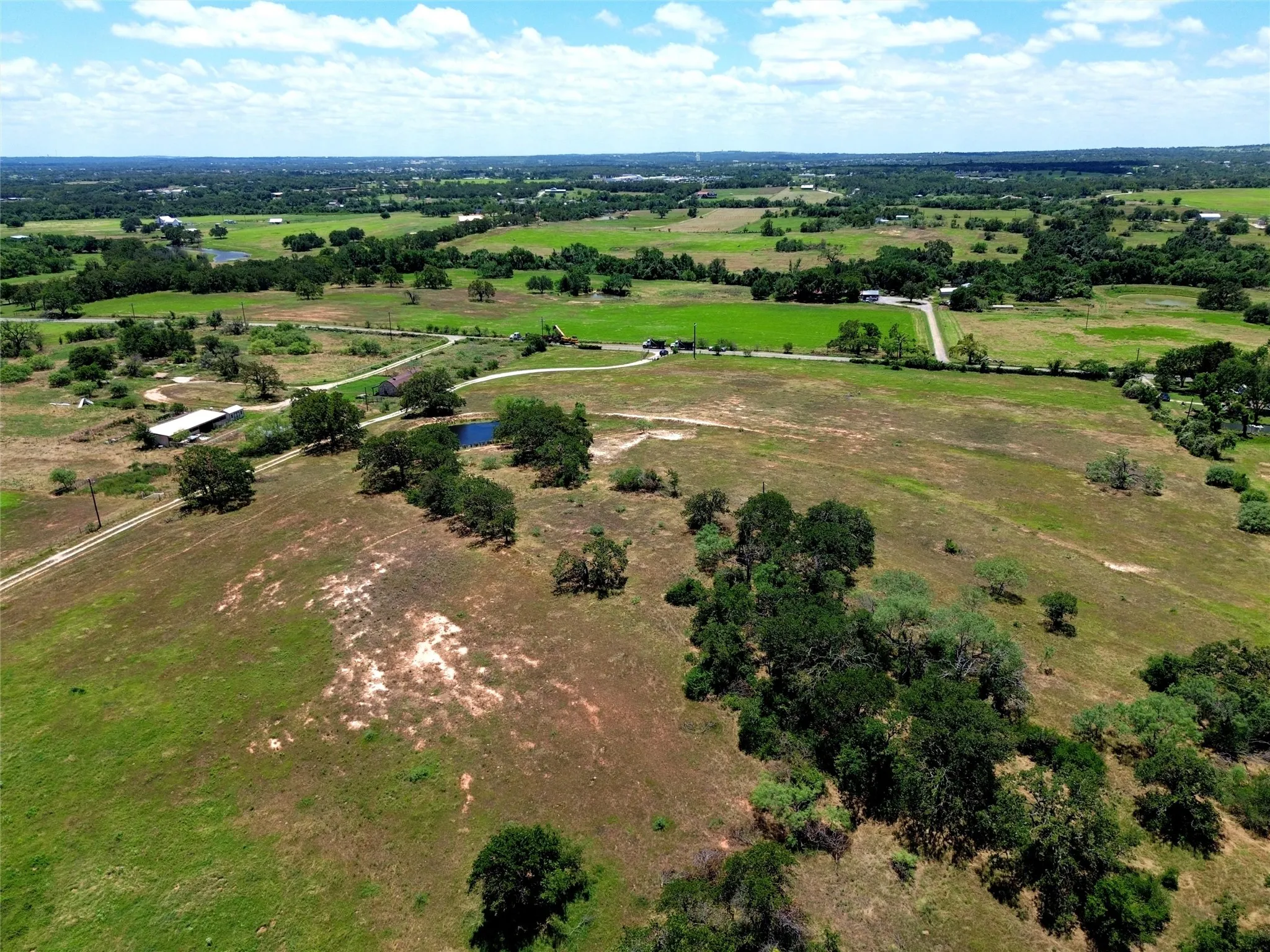 Expansive rural landscape featuring multiple clearings, mature trees, and natural water features