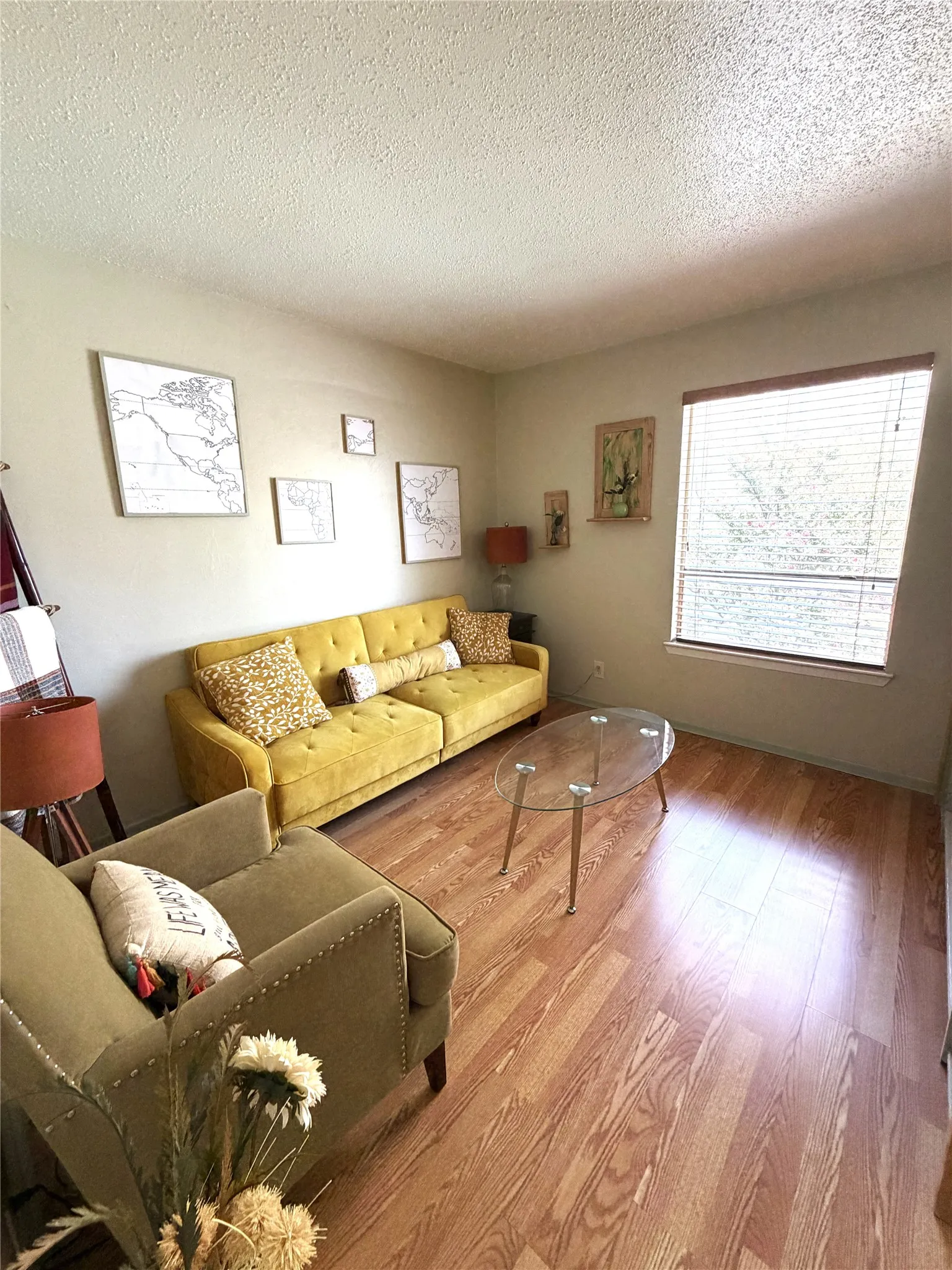 Hardwood flooring, textured ceiling, and window with blinds
