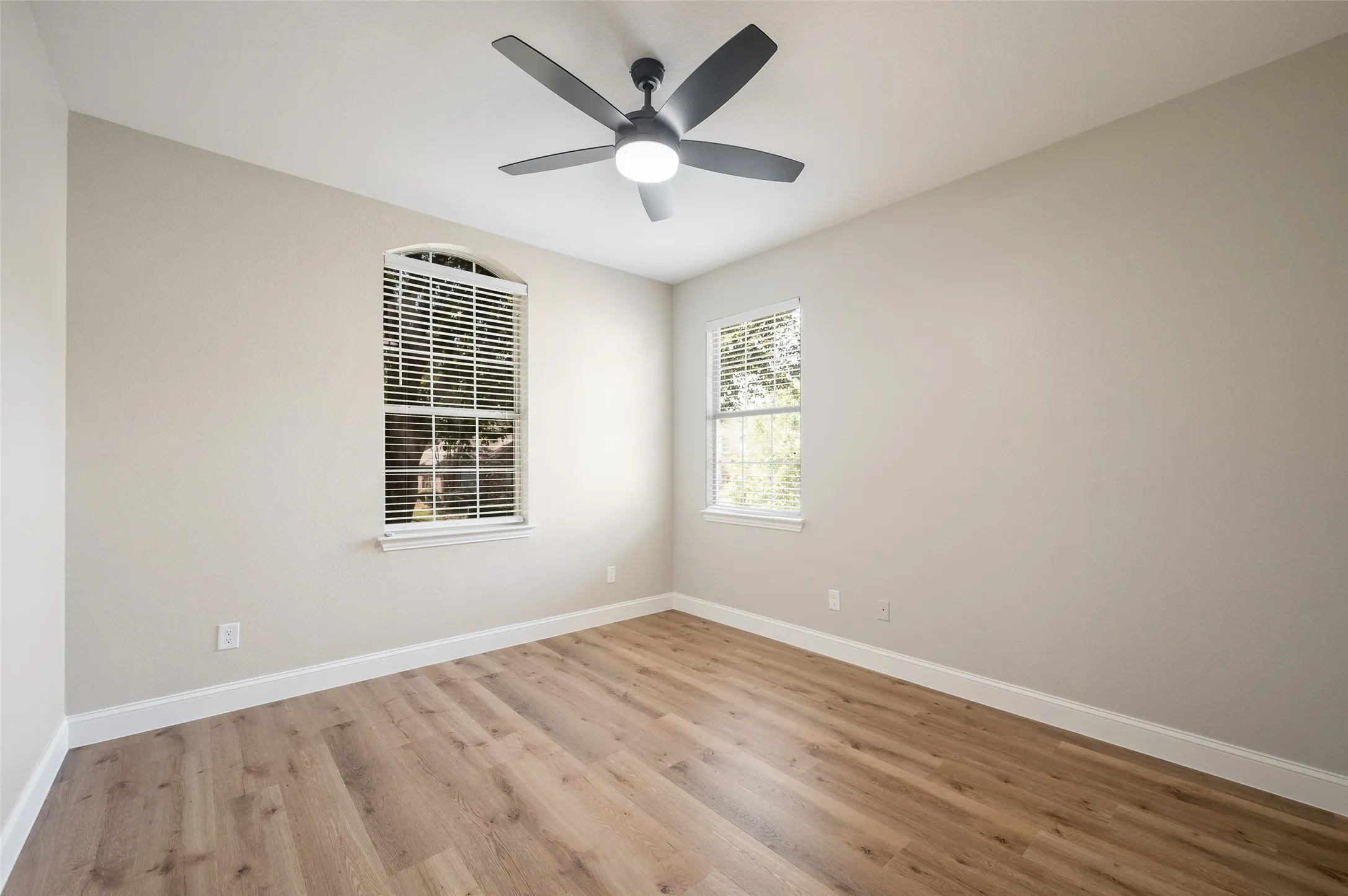 3rd bedroom with updated fan, beautiful flooring and 2 widows that look out to front yard.