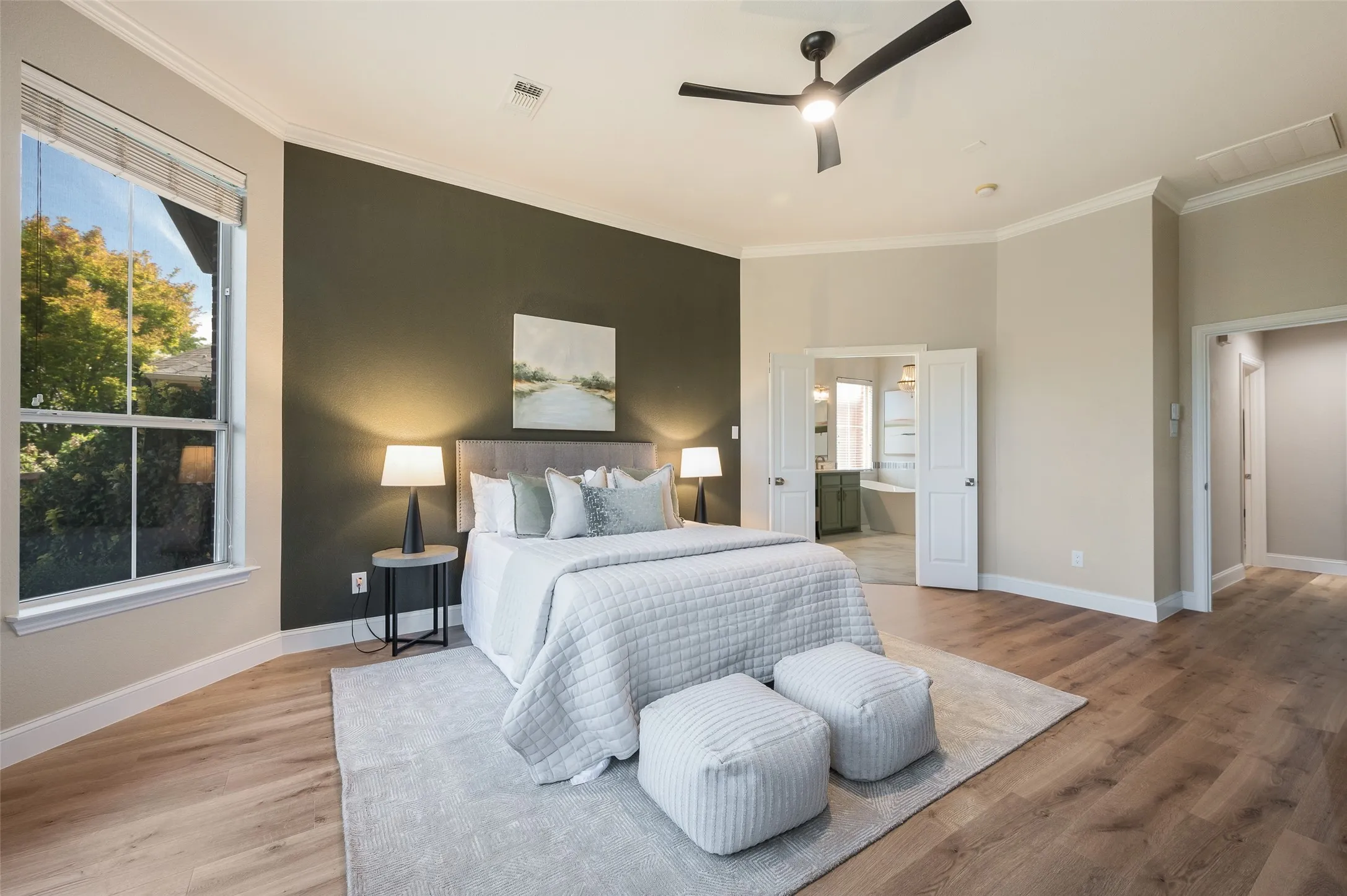 Stylish updated fan and beautiful flooring the continues into the primary bedroom.