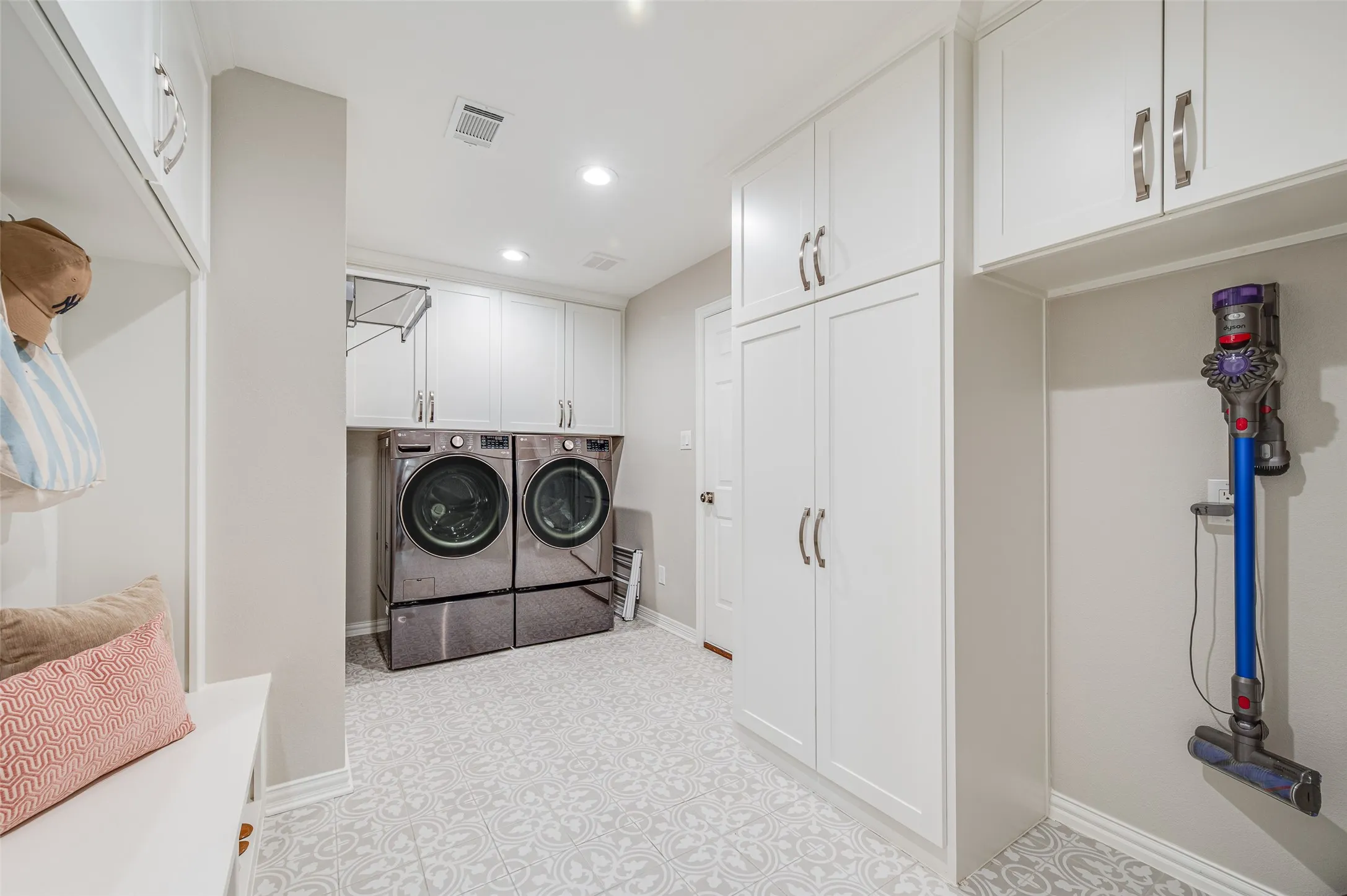 Large dream Laundry room with beautiful tile and custom cabinetry.