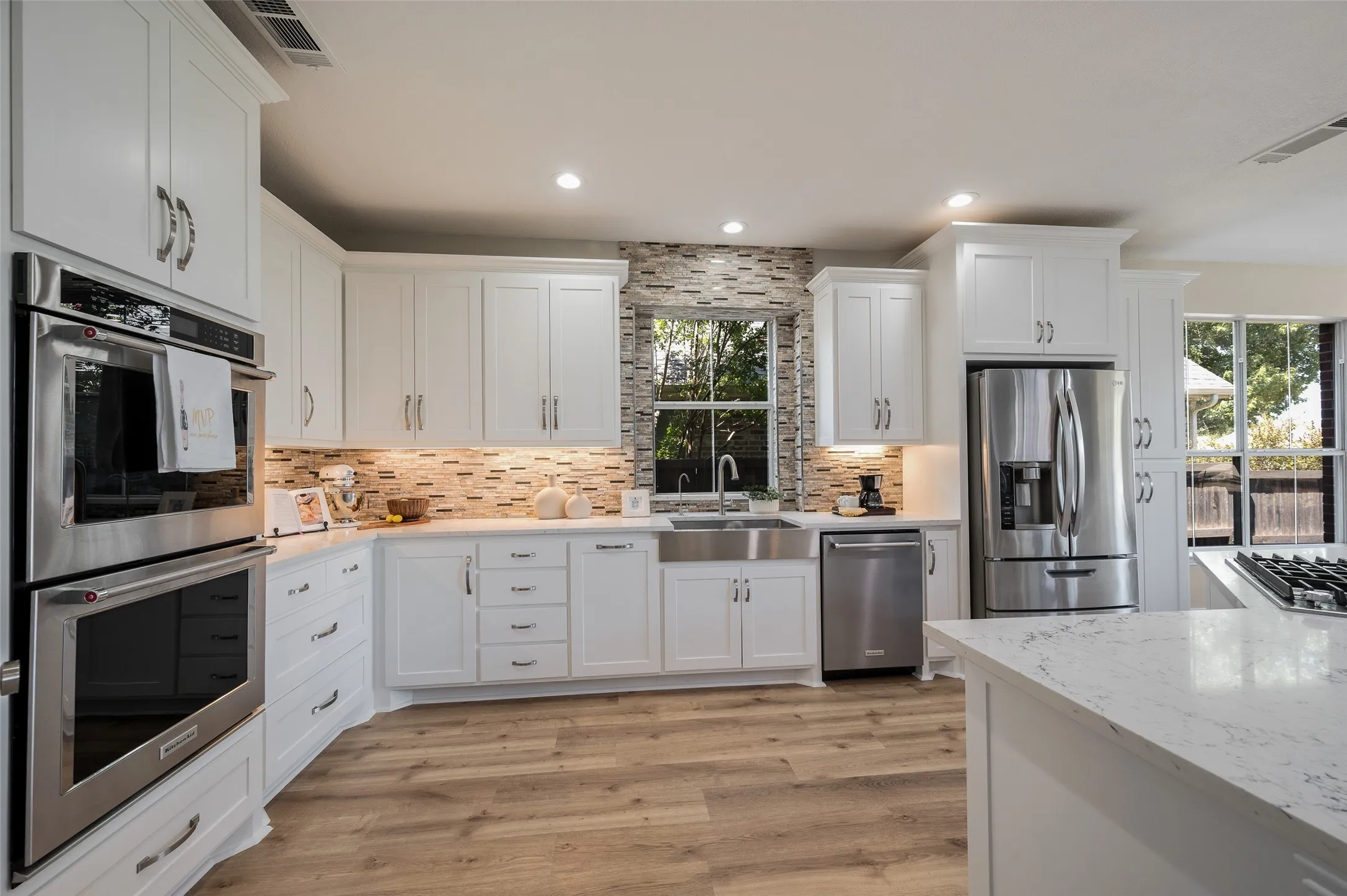 Large roomy kitchen with freshly painted cabinetry and beautiful appliances.