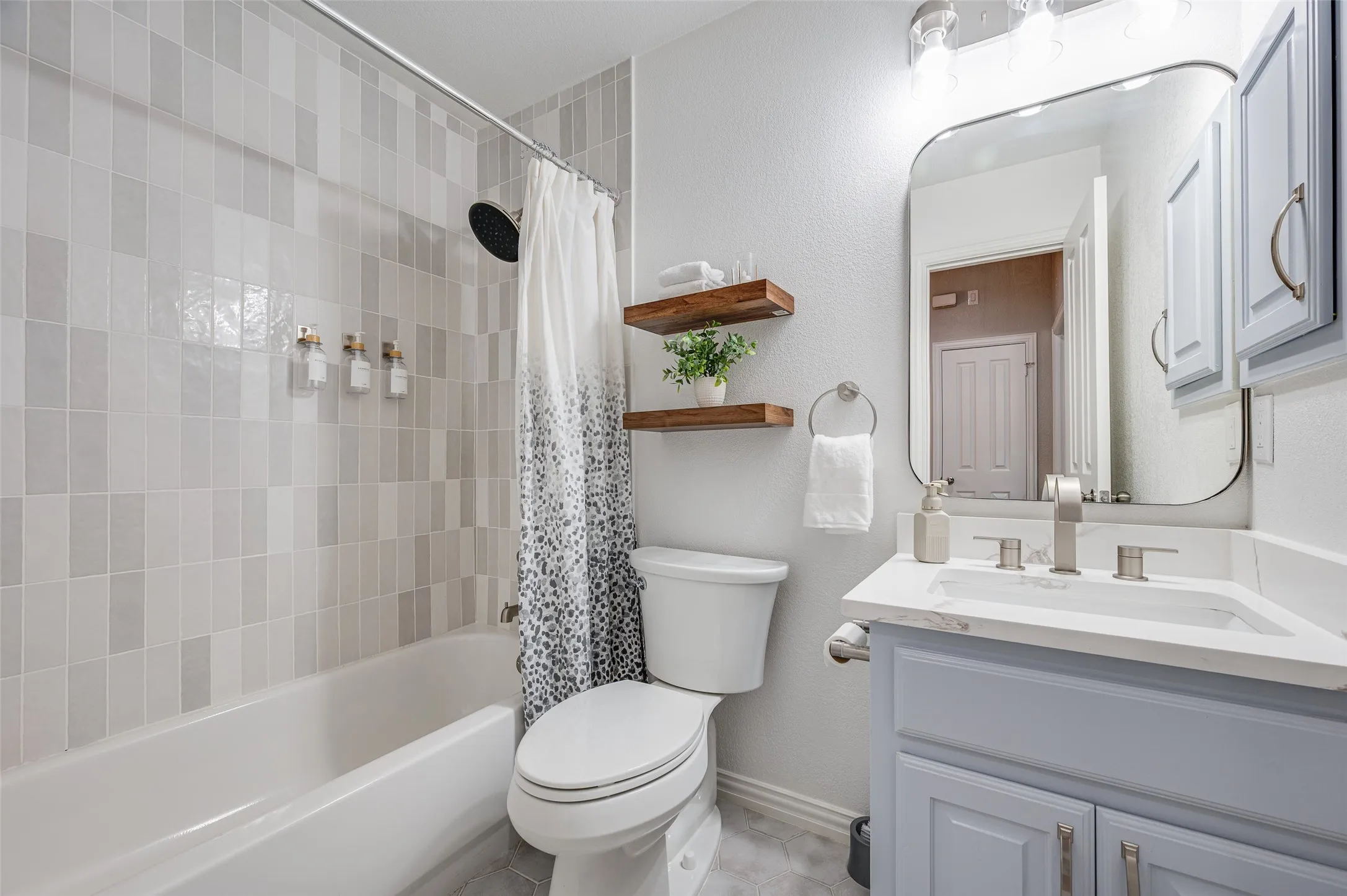 Beautifully updated 2nd bath features stunning tile, a framed mirror and beautifully freshly painted vanity.