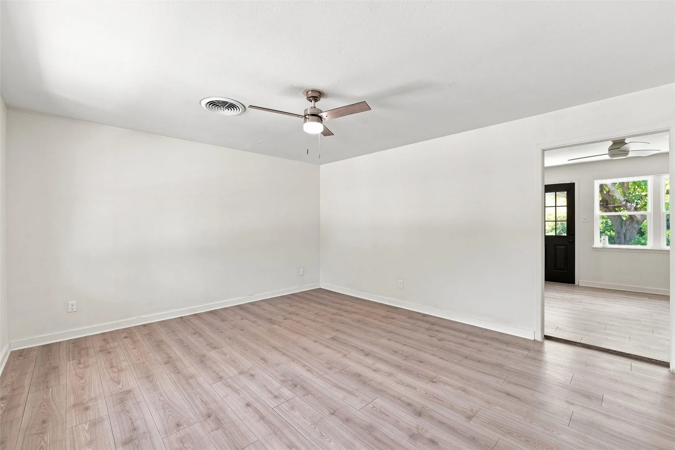 Wood-finish flooring throughout, complemented by a ceiling fan with integrated lighting