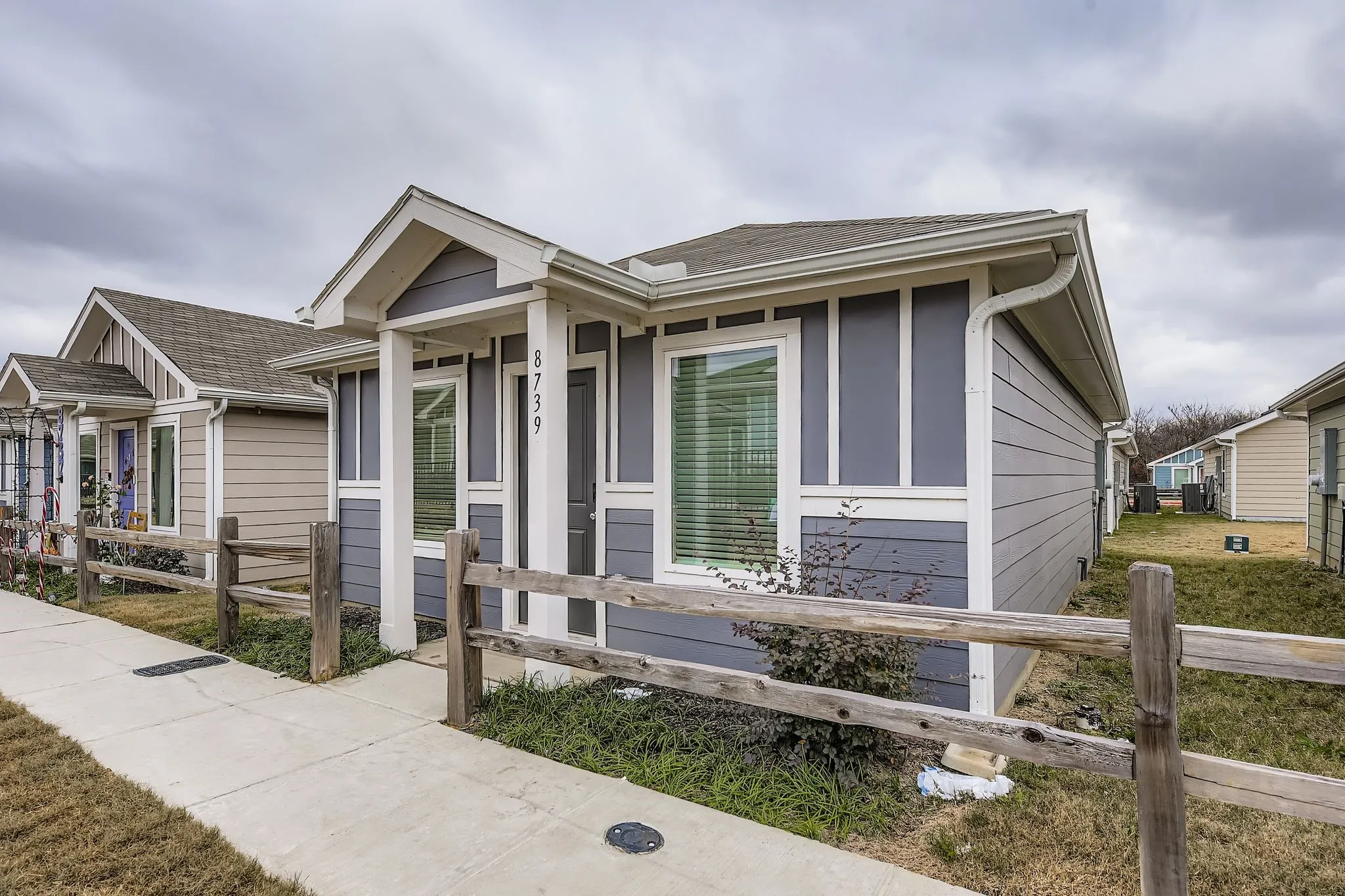 Exterior featuring horizontal siding, vertical accent panels, an entry porch, and a sidewalk