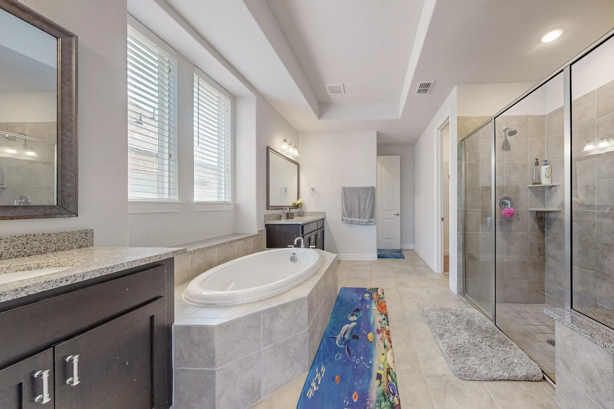 Bathroom featuring vanity, plus walk in shower, and tile patterned flooring