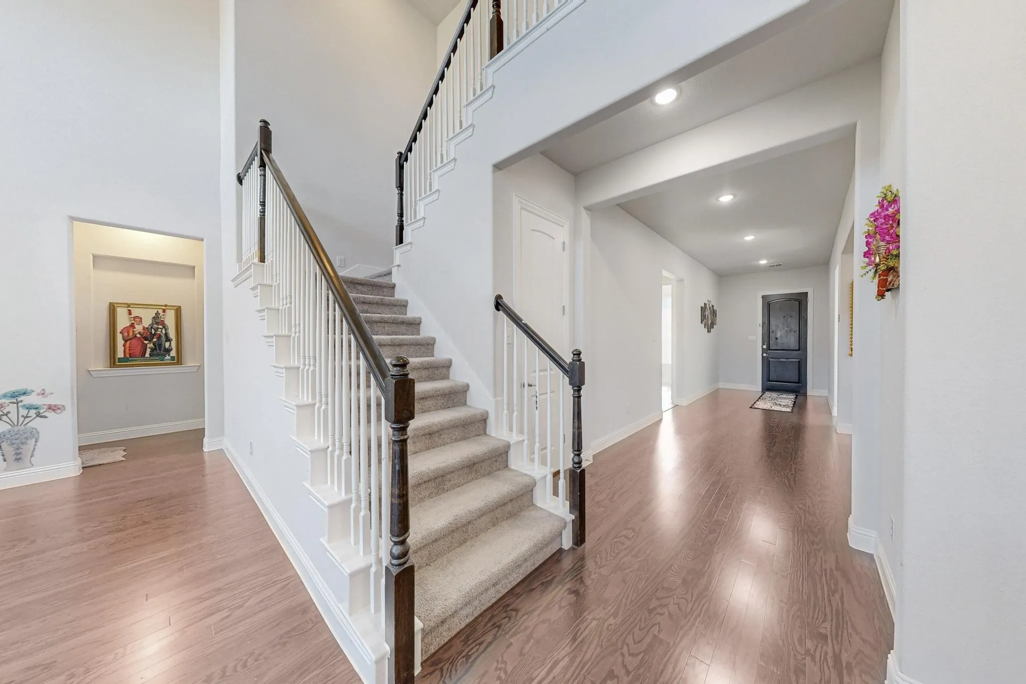 Stairway featuring hardwood / wood-style floors and a towering ceiling