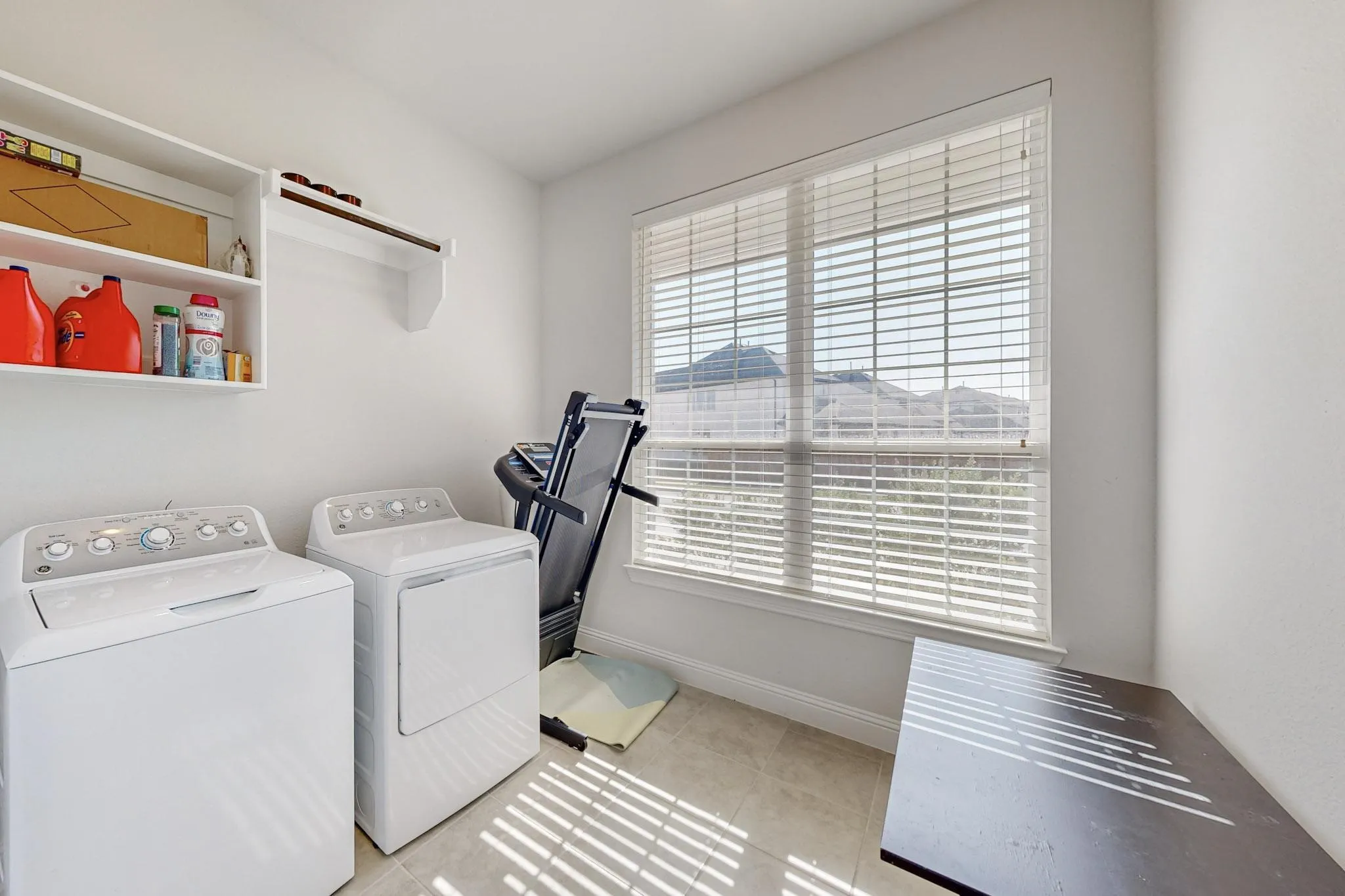 Laundry room featuring independent washer and dryer, a healthy amount of sunlight, and light tile patterned floors