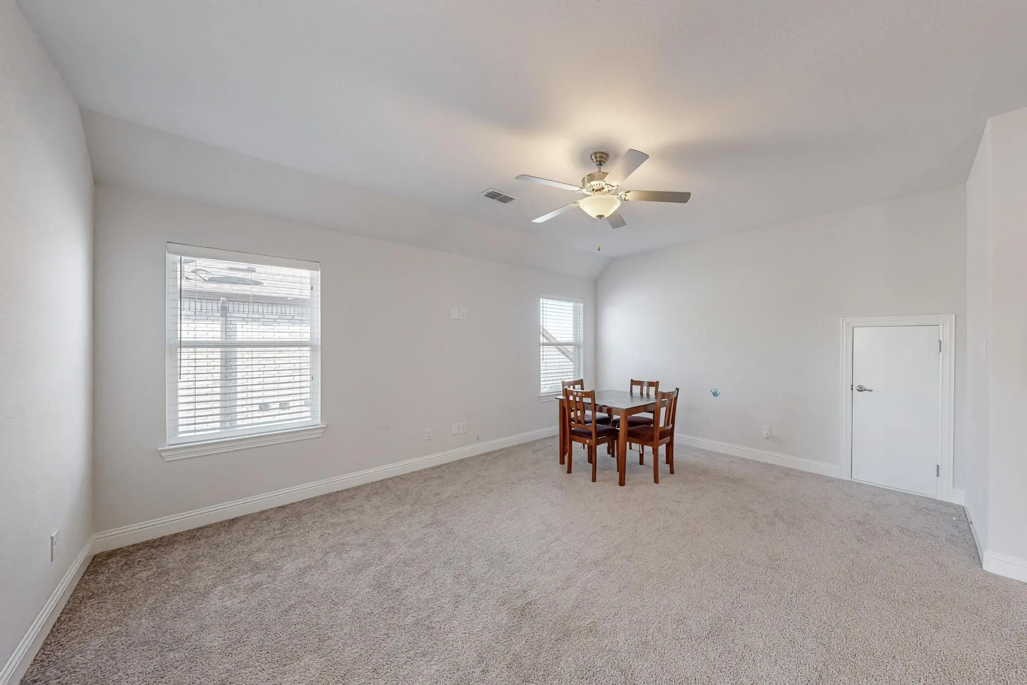 Dining space featuring light carpet, ceiling fan, and a wealth of natural light