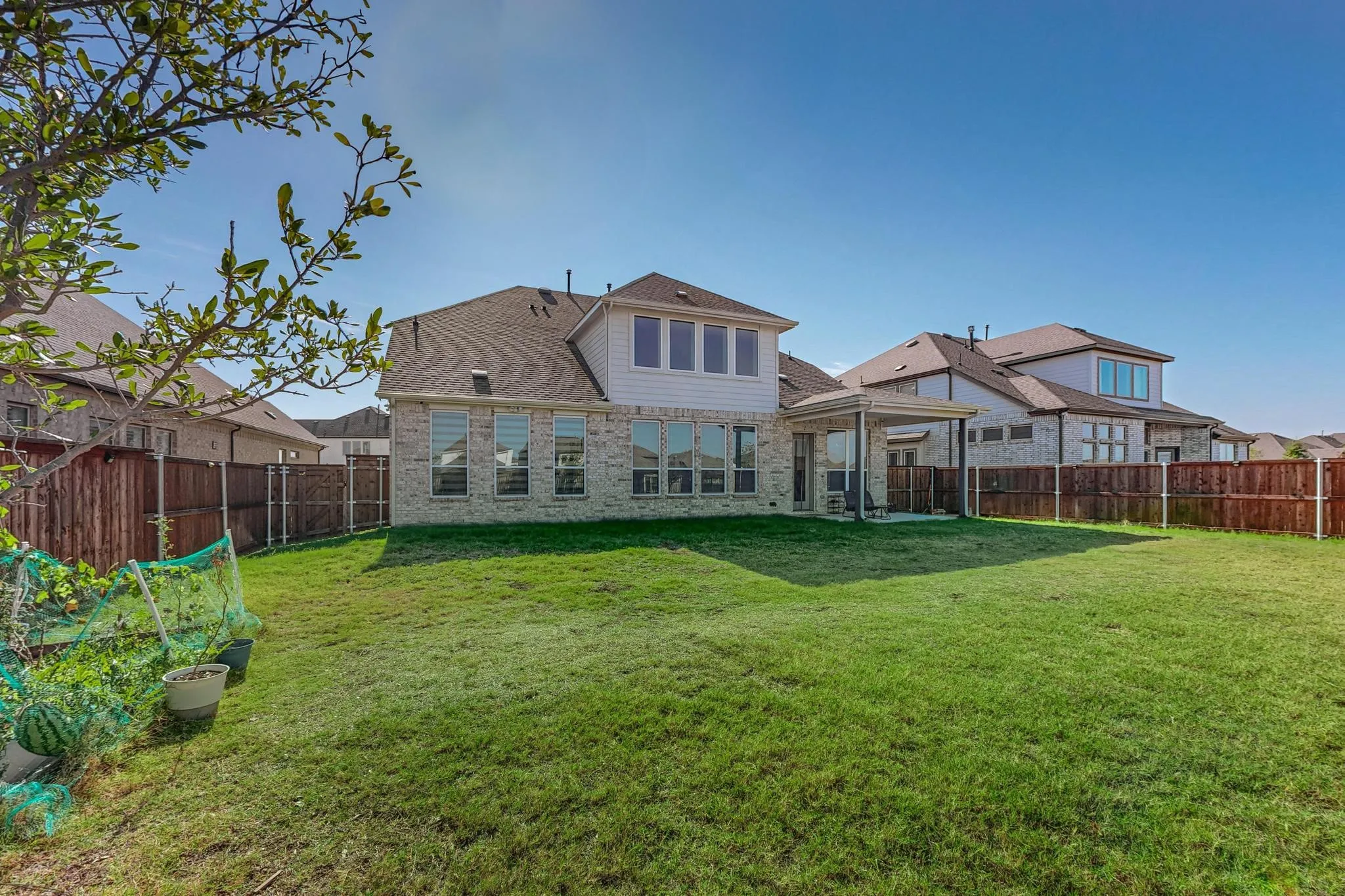 Rear view of property with a patio area and a lawn
