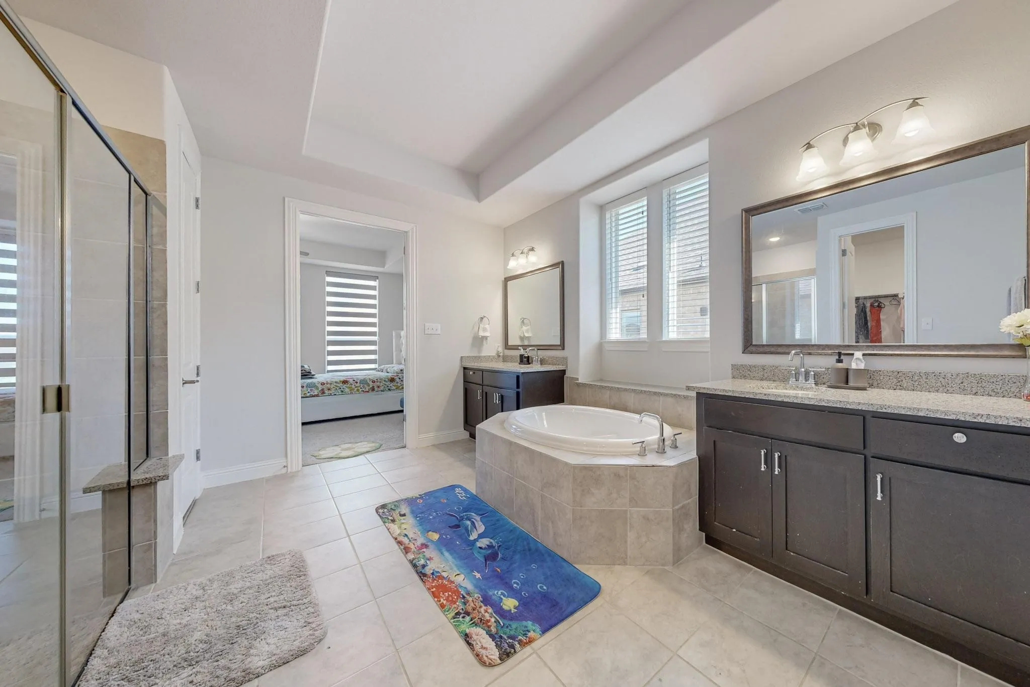 Bathroom with vanity, plus walk in shower, plenty of natural light, and tile patterned flooring