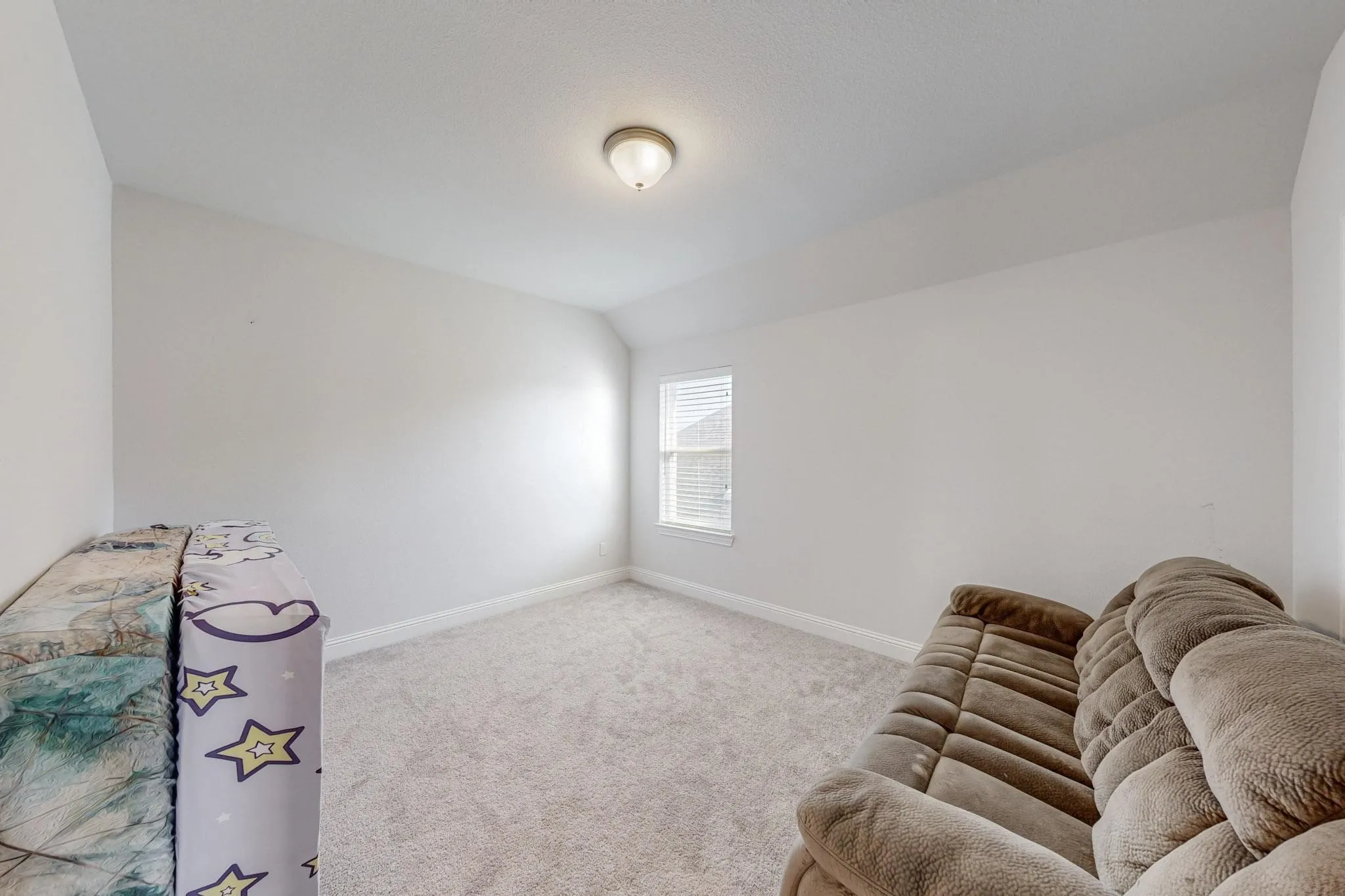 Sitting room with lofted ceiling and light carpet