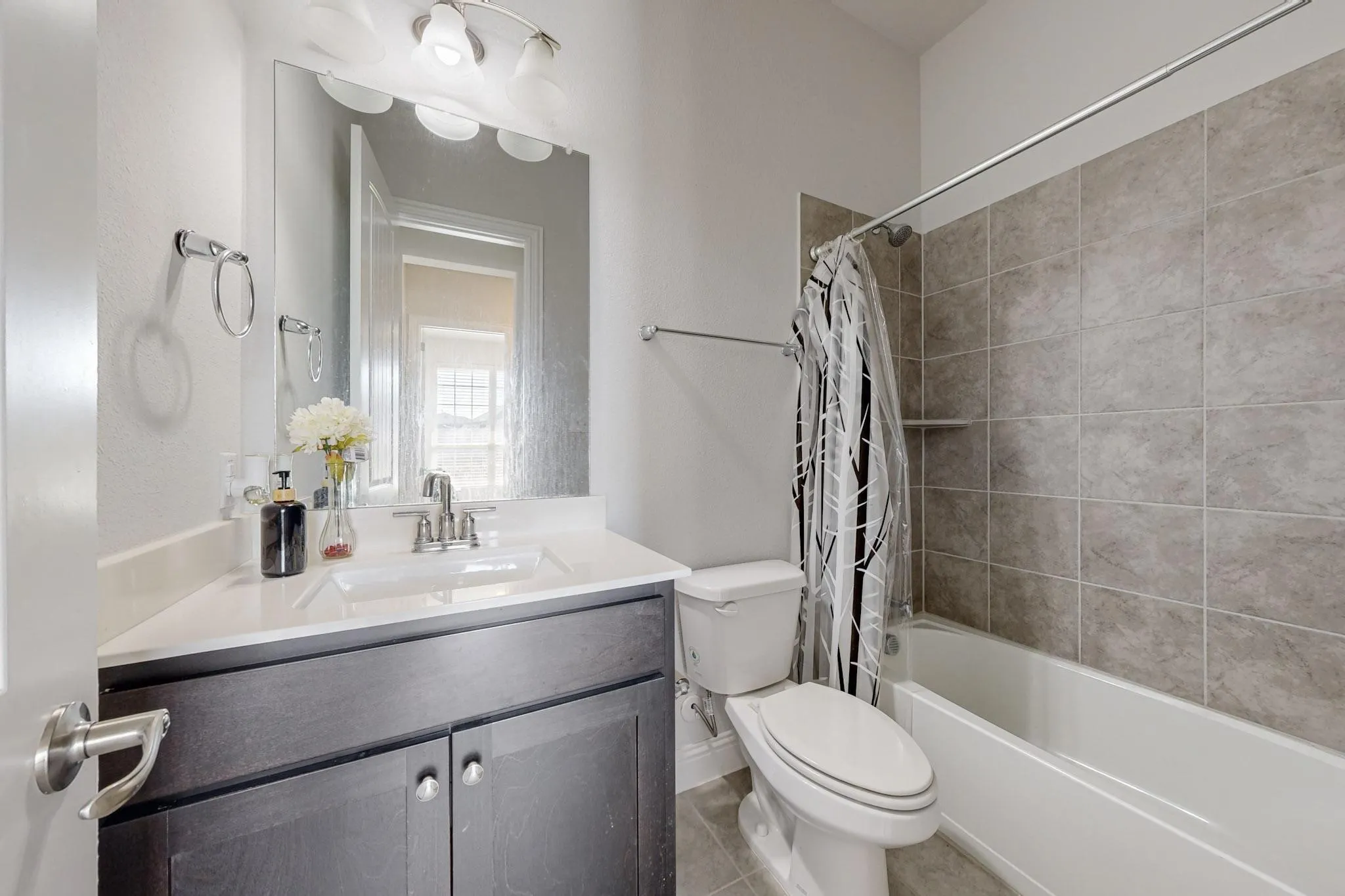 Full bathroom featuring vanity, shower / tub combo with curtain, toilet, and tile patterned flooring