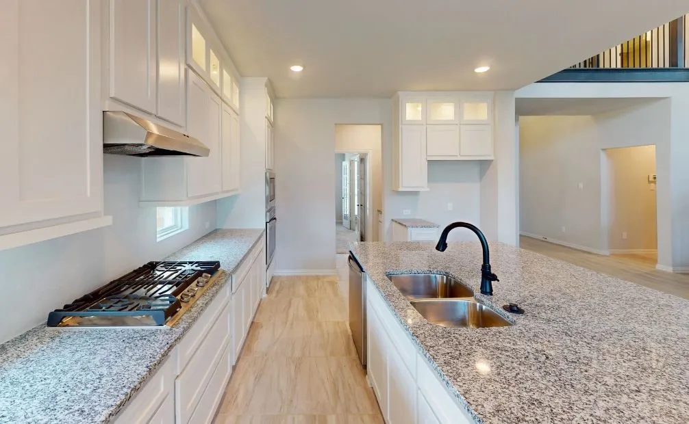 Kitchen featuring white shaker cabinetry, stainless steel appliances, granite countertops, a double basin sink, and tile flooring