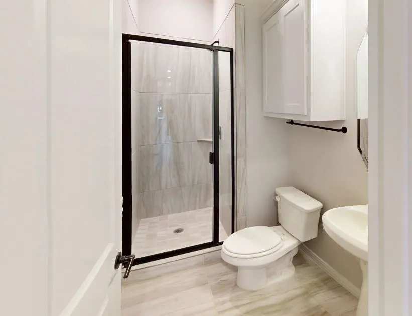 Walk-in shower with a black-framed glass enclosure and tiled walls