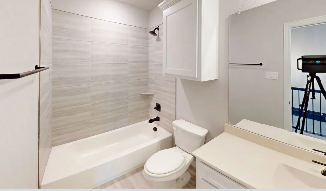 White vanity with a neutral countertop, undermount sink, and matte black faucet