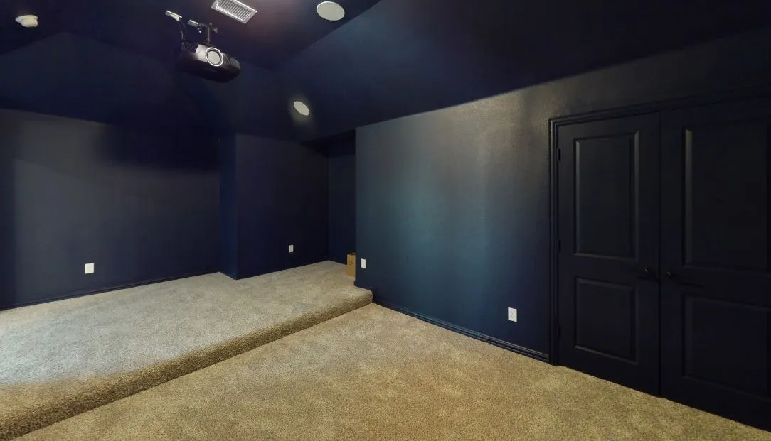 Raised platform seating, integrated ceiling projector, recessed lighting, double panel doors, and wall-to-wall carpeting