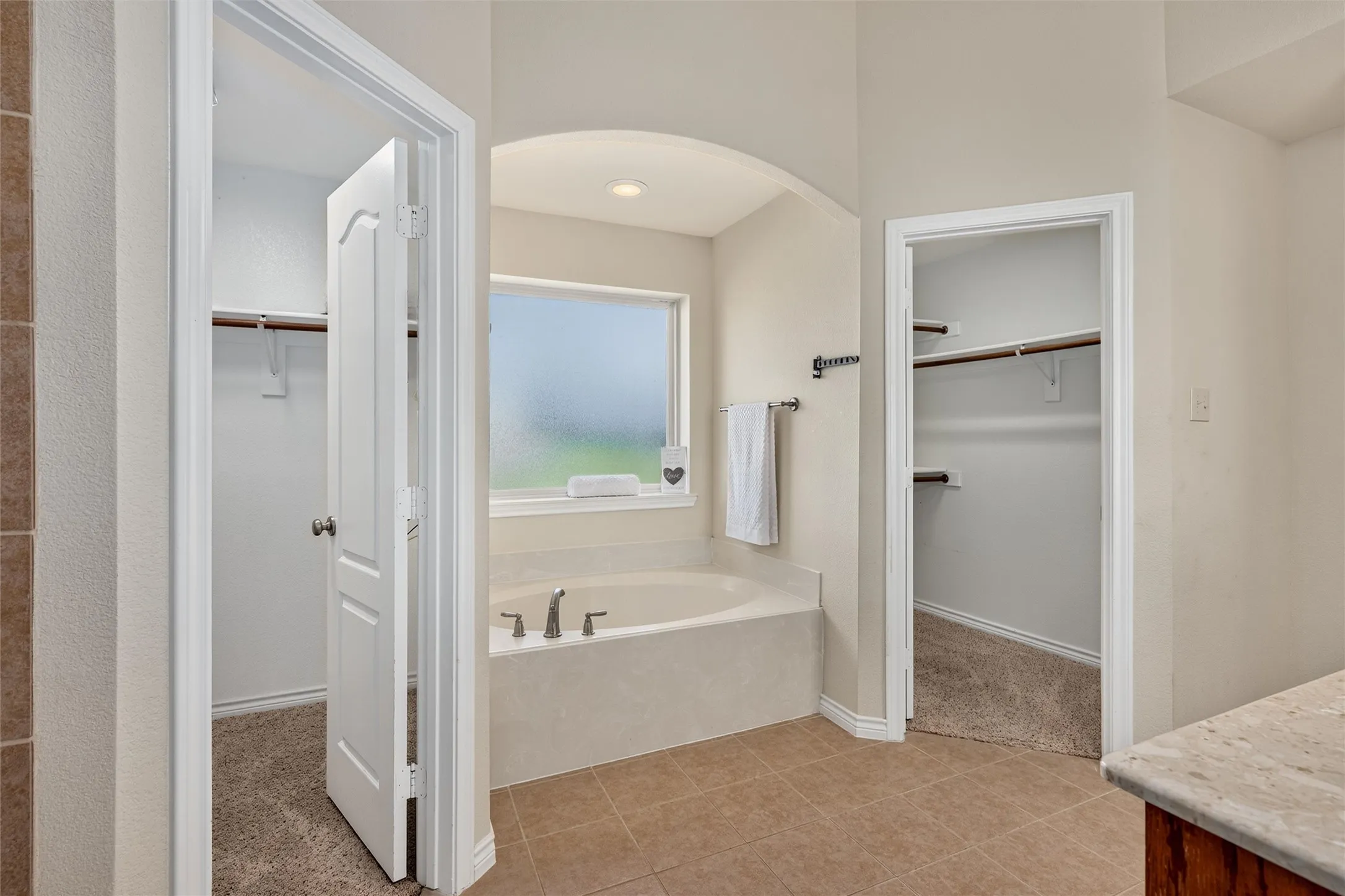 2 walk in closets in the primary bath with garden tub