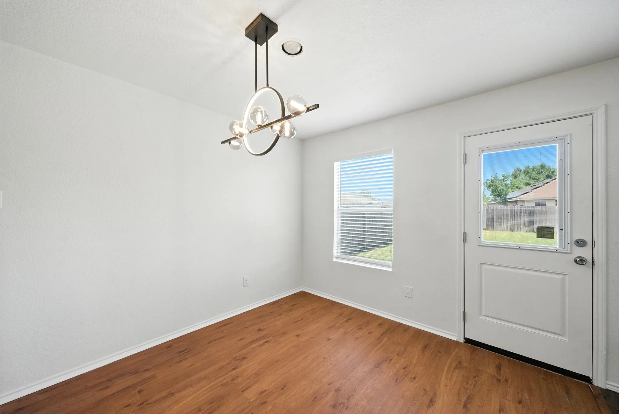Entrance foyer with wood finished floors, plenty of natural light, and a chandelier