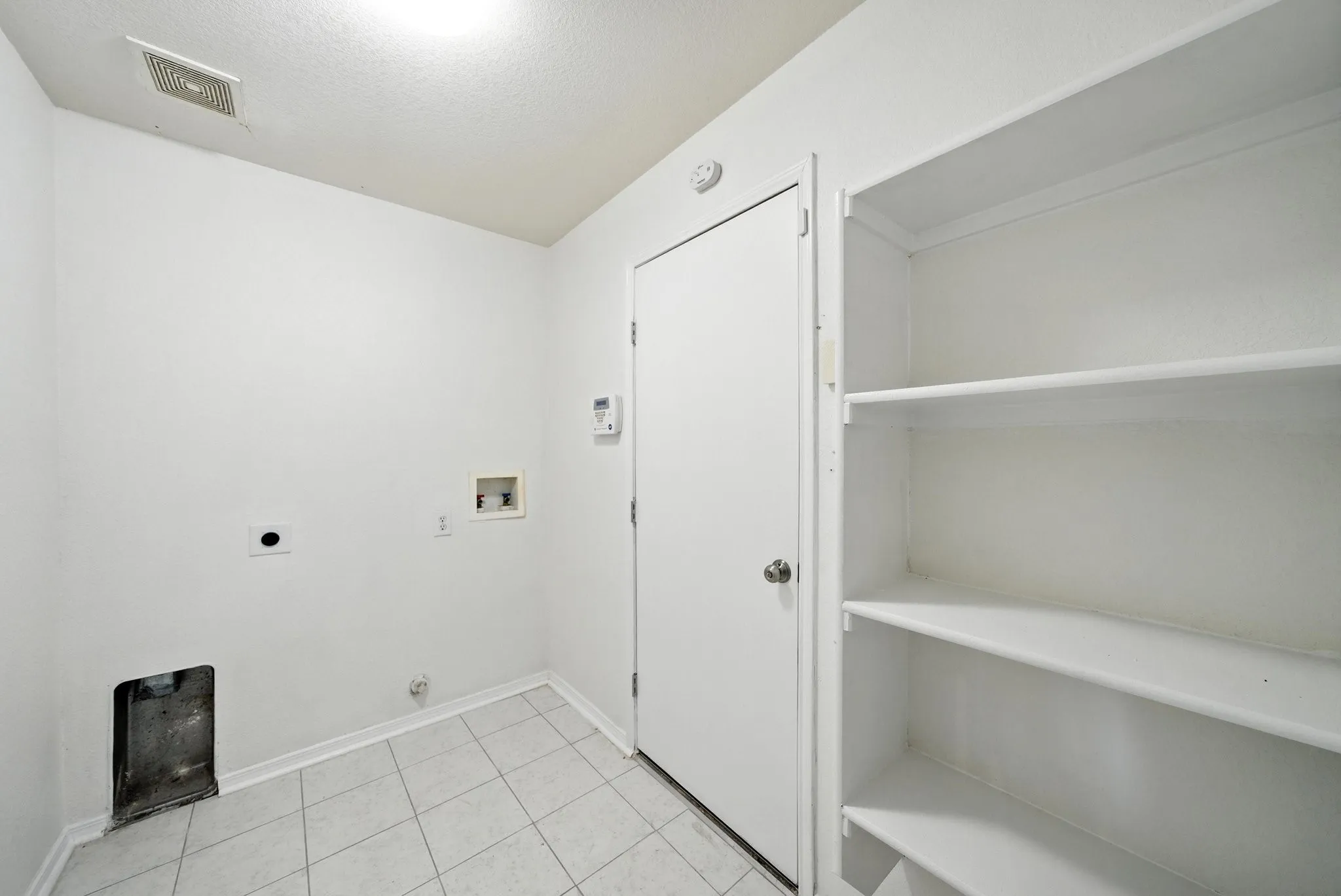Washroom featuring electric dryer hookup, hookup for a washing machine, light tile patterned flooring, and a textured ceiling
