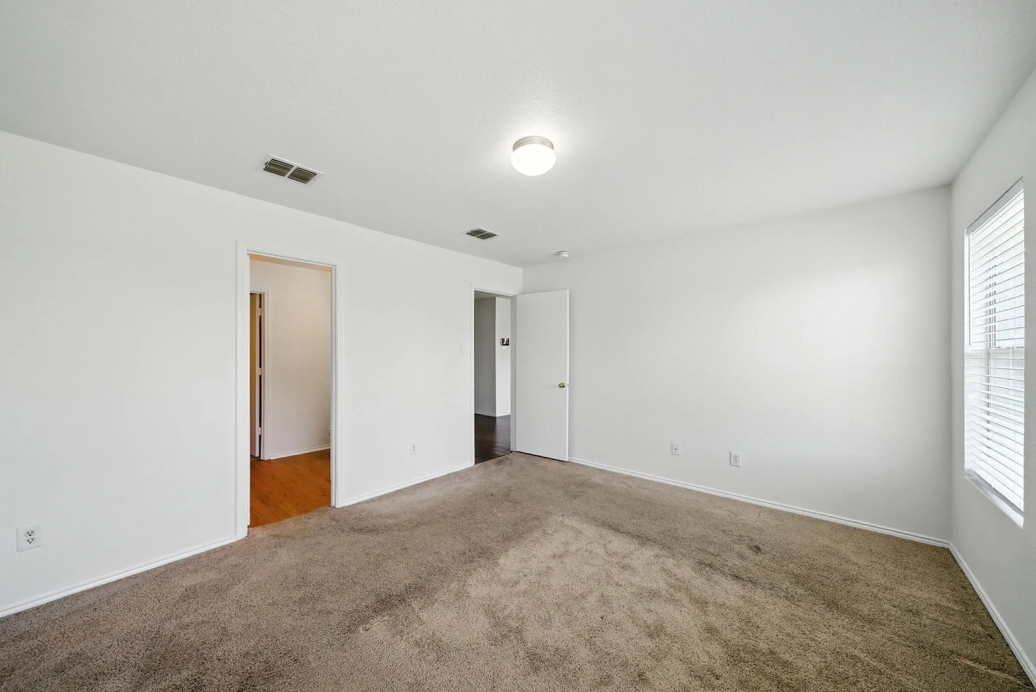 Empty room with carpet floors and baseboards