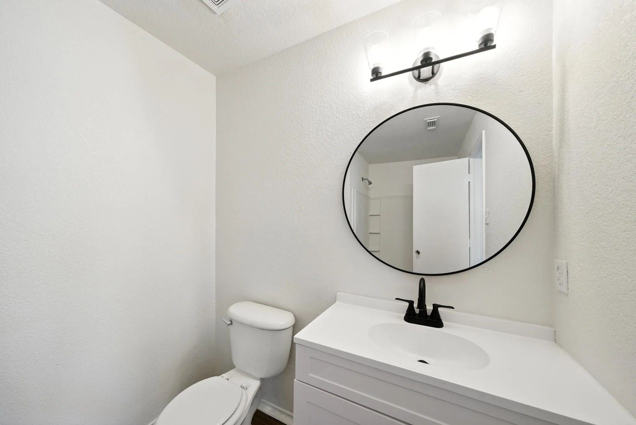 Half bathroom with vanity and toilet