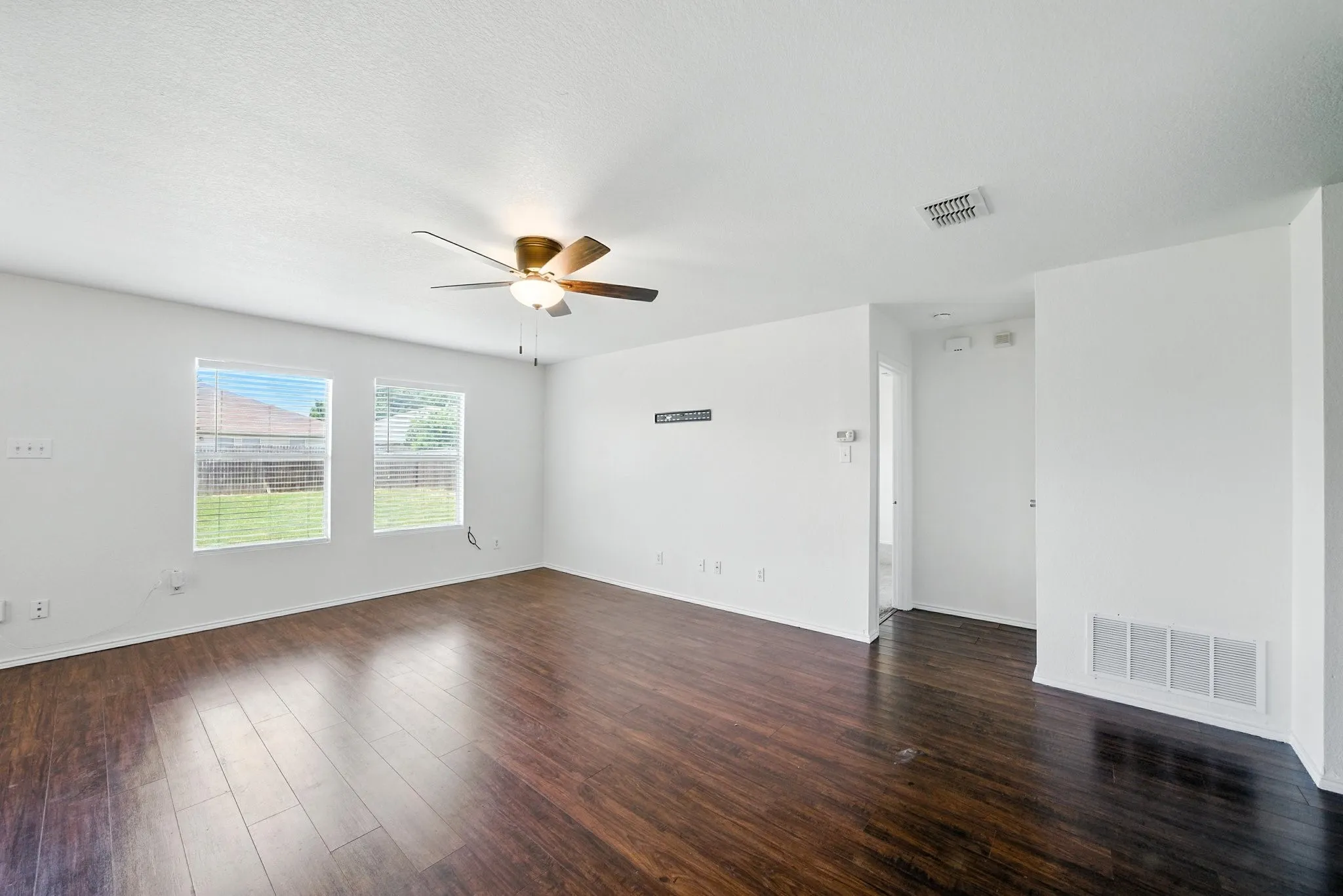 Unfurnished room with ceiling fan and dark wood-style flooring