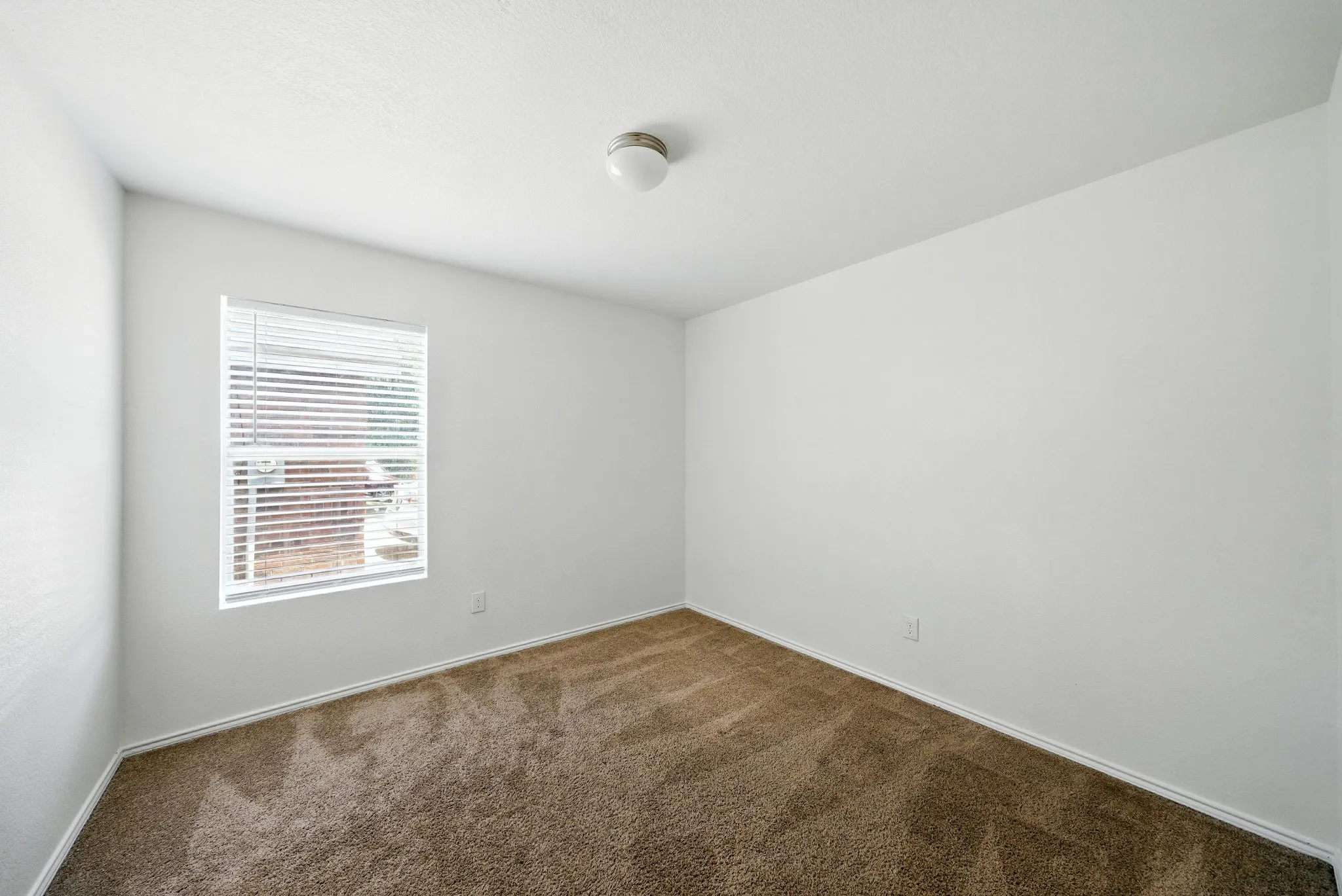 Carpeted spare room featuring baseboards