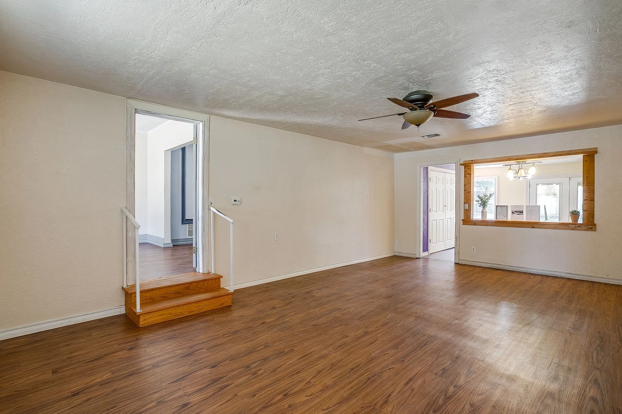 Open Living room with door leading into primary bedroom