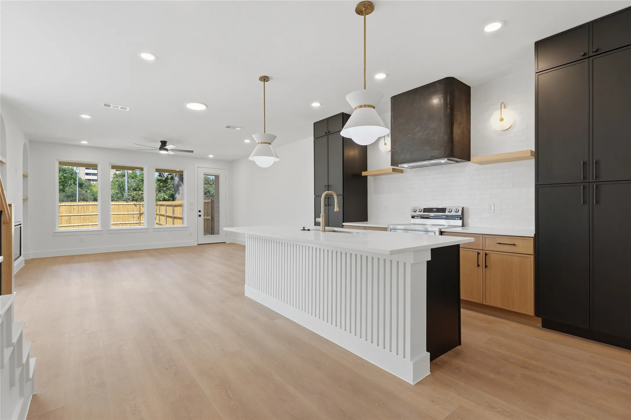 Open-concept design featuring wood-finish flooring, recessed lighting, and a modern kitchen