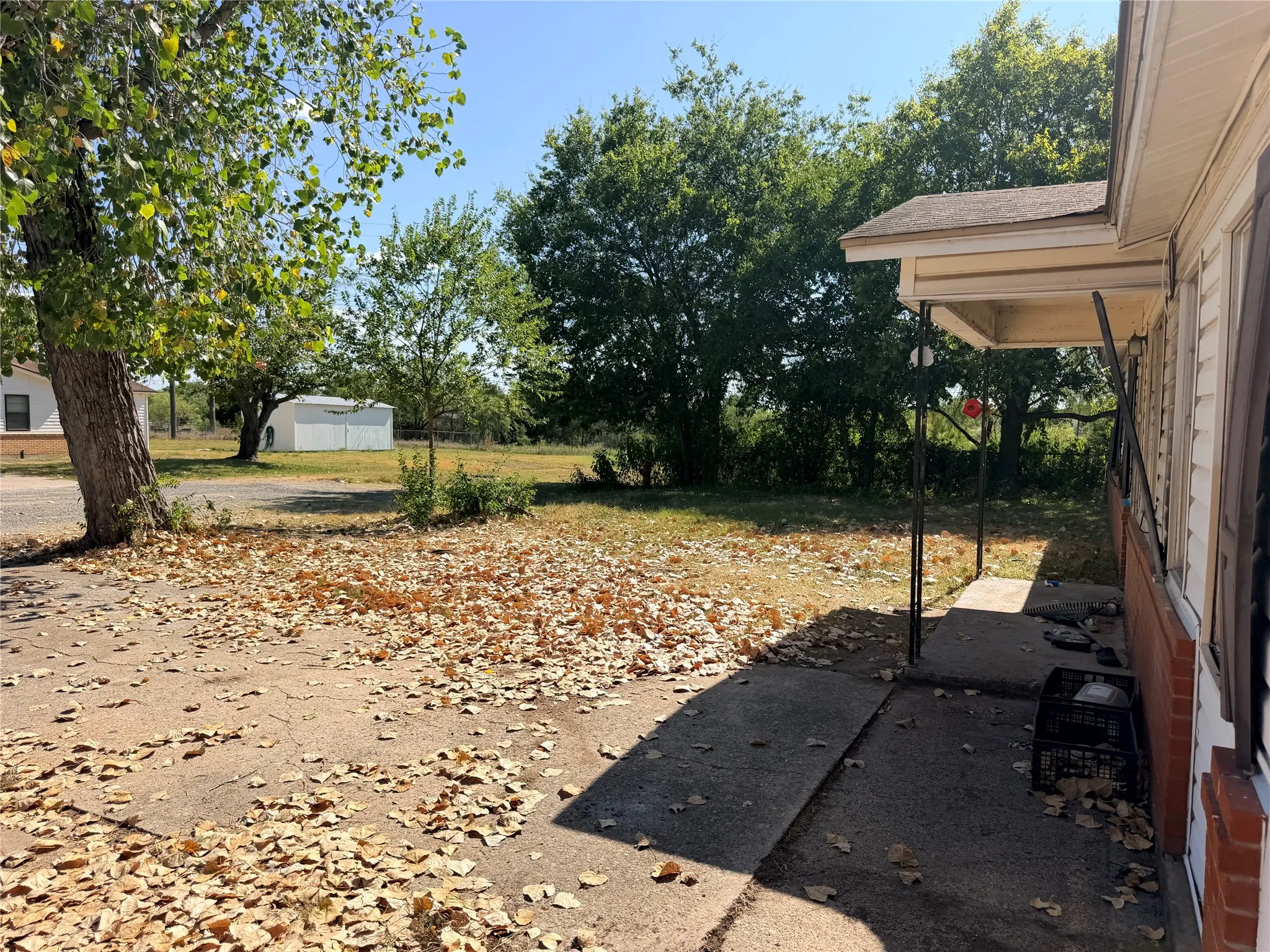 Concrete porch with metal supports, exterior siding, and brick foundation