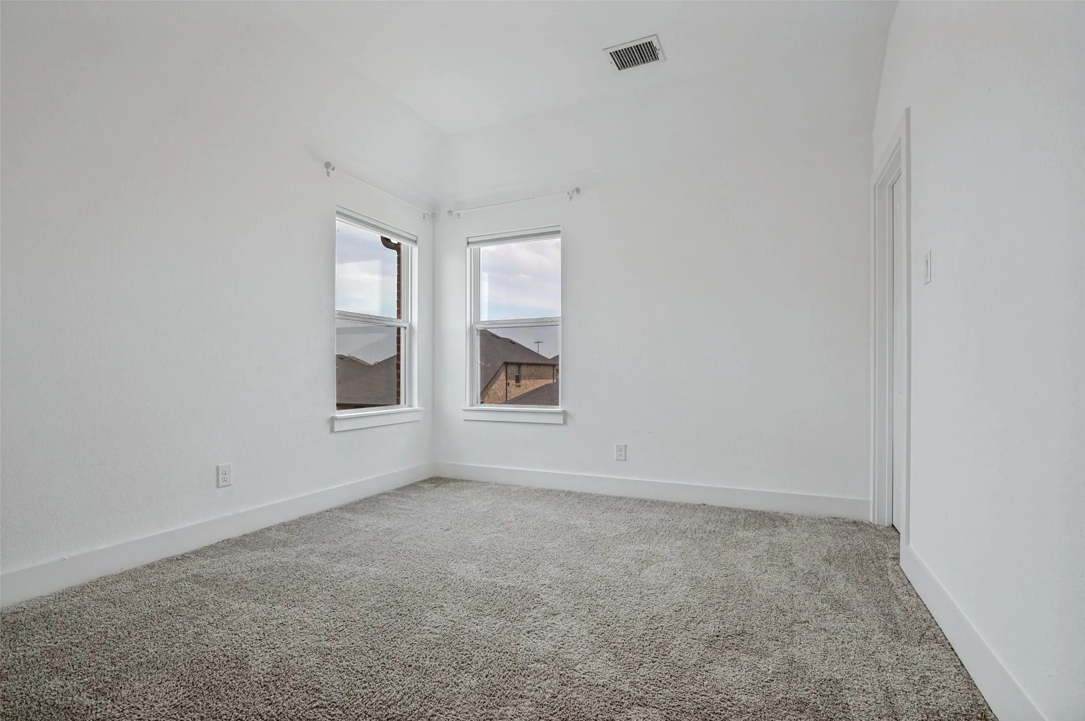 Neutral wall finishes, recessed ceiling detail, and two windows